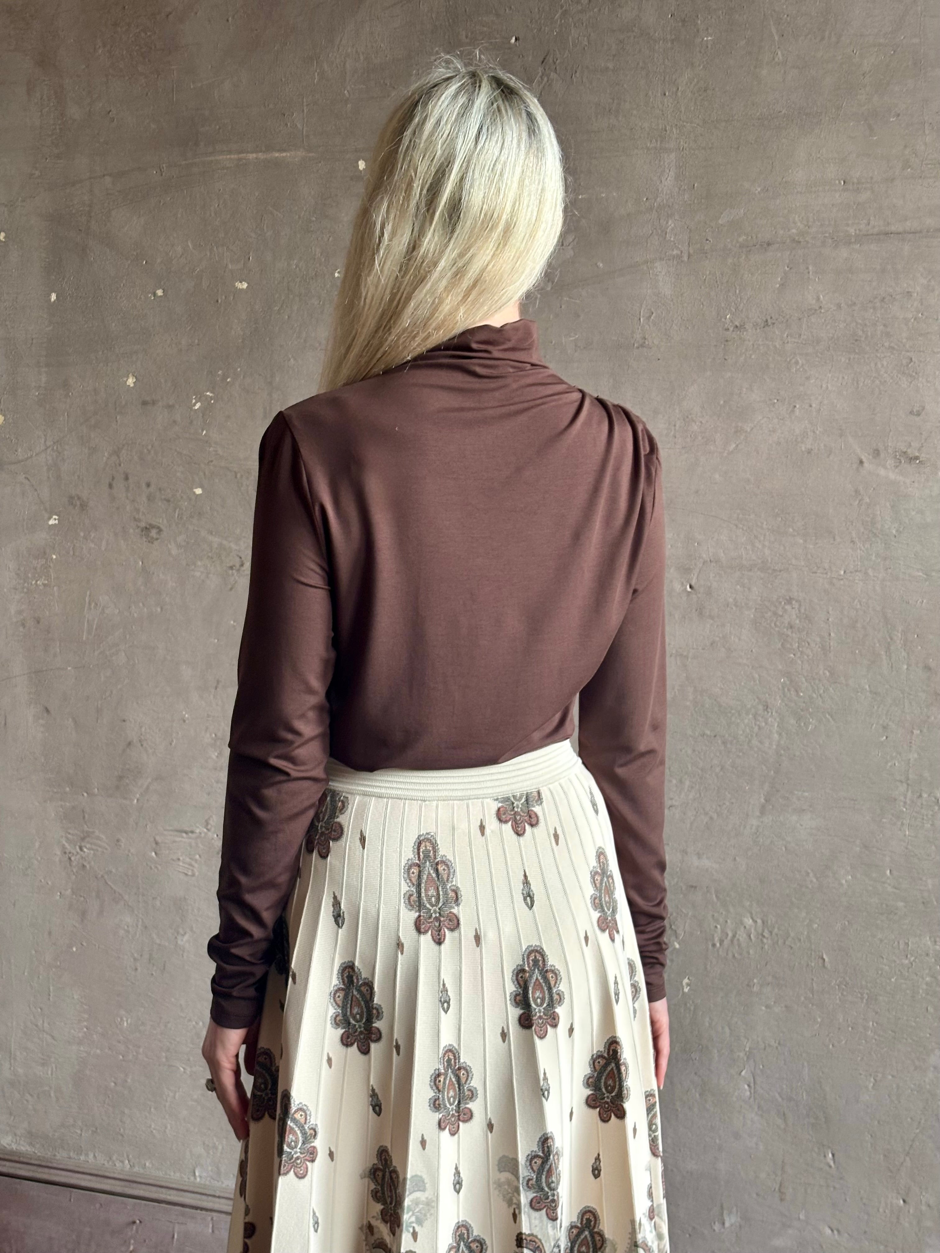 Mature woman wearing Veronica Beard's Mylie Top in Espresso brown lightweight lyocell with asymmetrical shoulder draping and side ruching