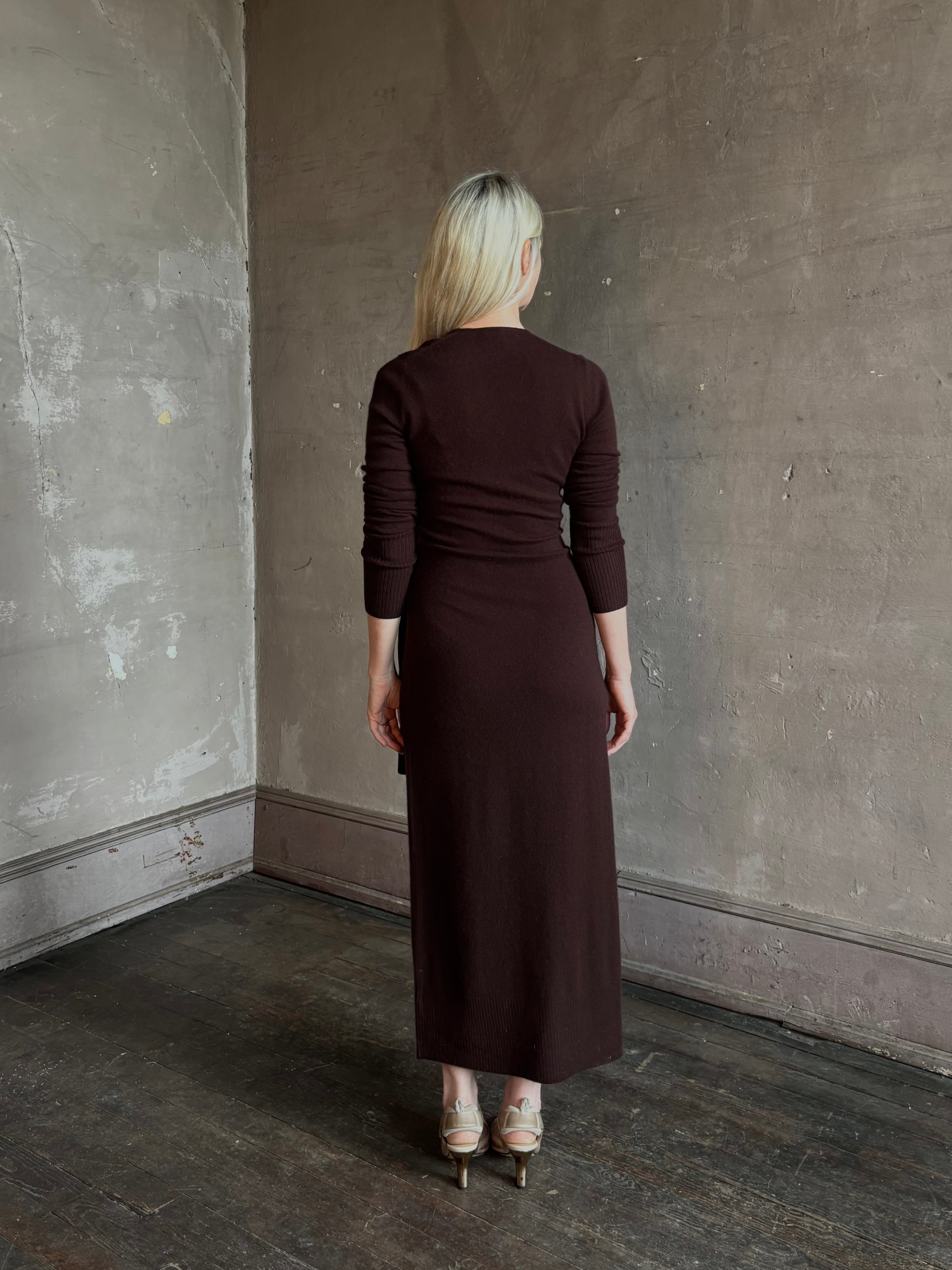 Mature woman wearing Veronica Beard's Salomez Knit Dress in chocolate brown  wrap maxi with a V-neckline and side vent