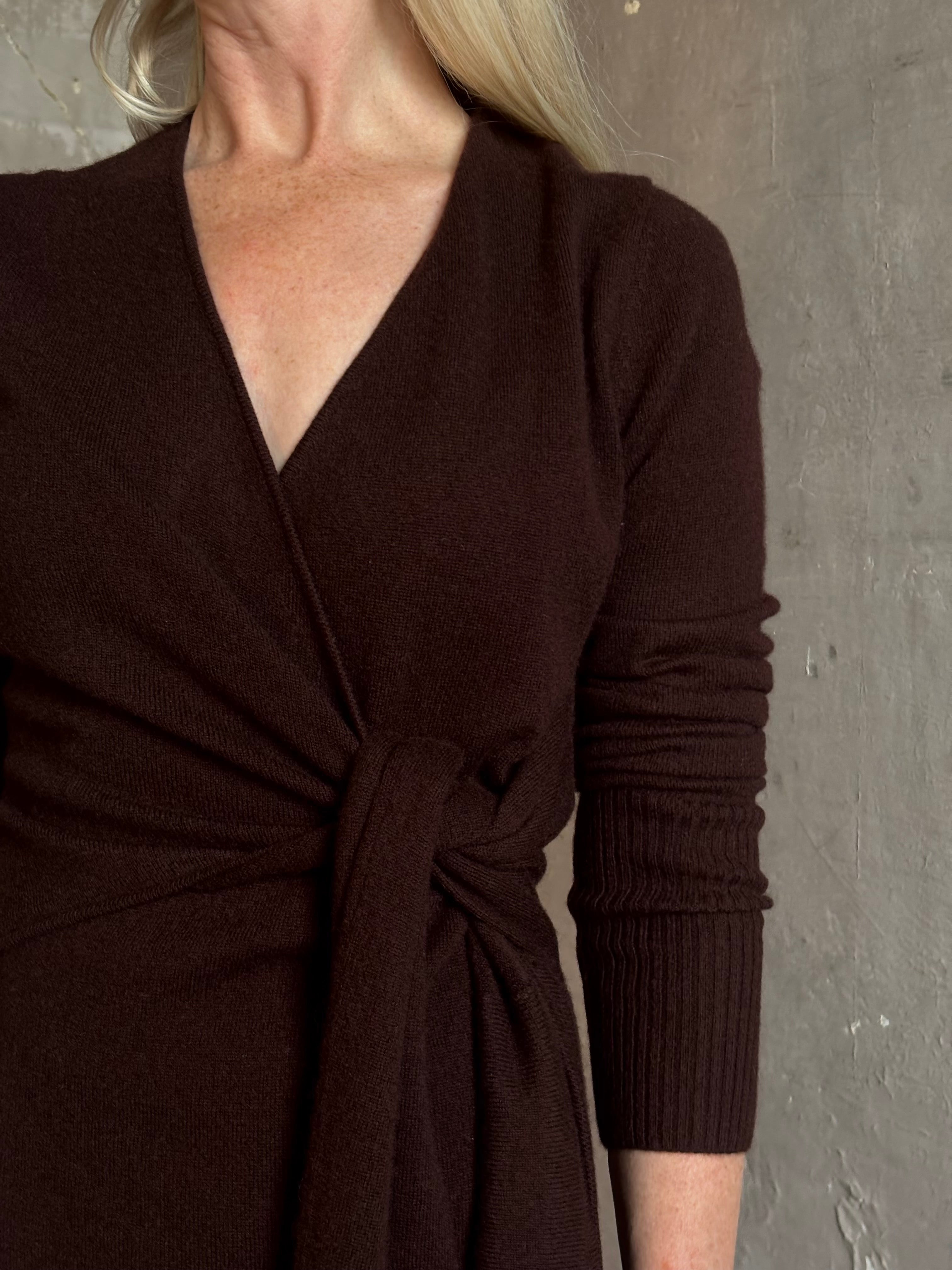 Mature woman wearing Veronica Beard's Salomez Knit Dress in chocolate brown  wrap maxi with a V-neckline and side vent