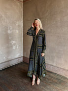 mature woman wearing Veronica Beard long-sleeved maxi skye dress with a dark blue green and gold geometric pattern