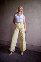 Mature woman wearing designer Veronica Beard butter yellow high rise crop taylor rigid 100% cotton denim jean with wide leg and made in USA