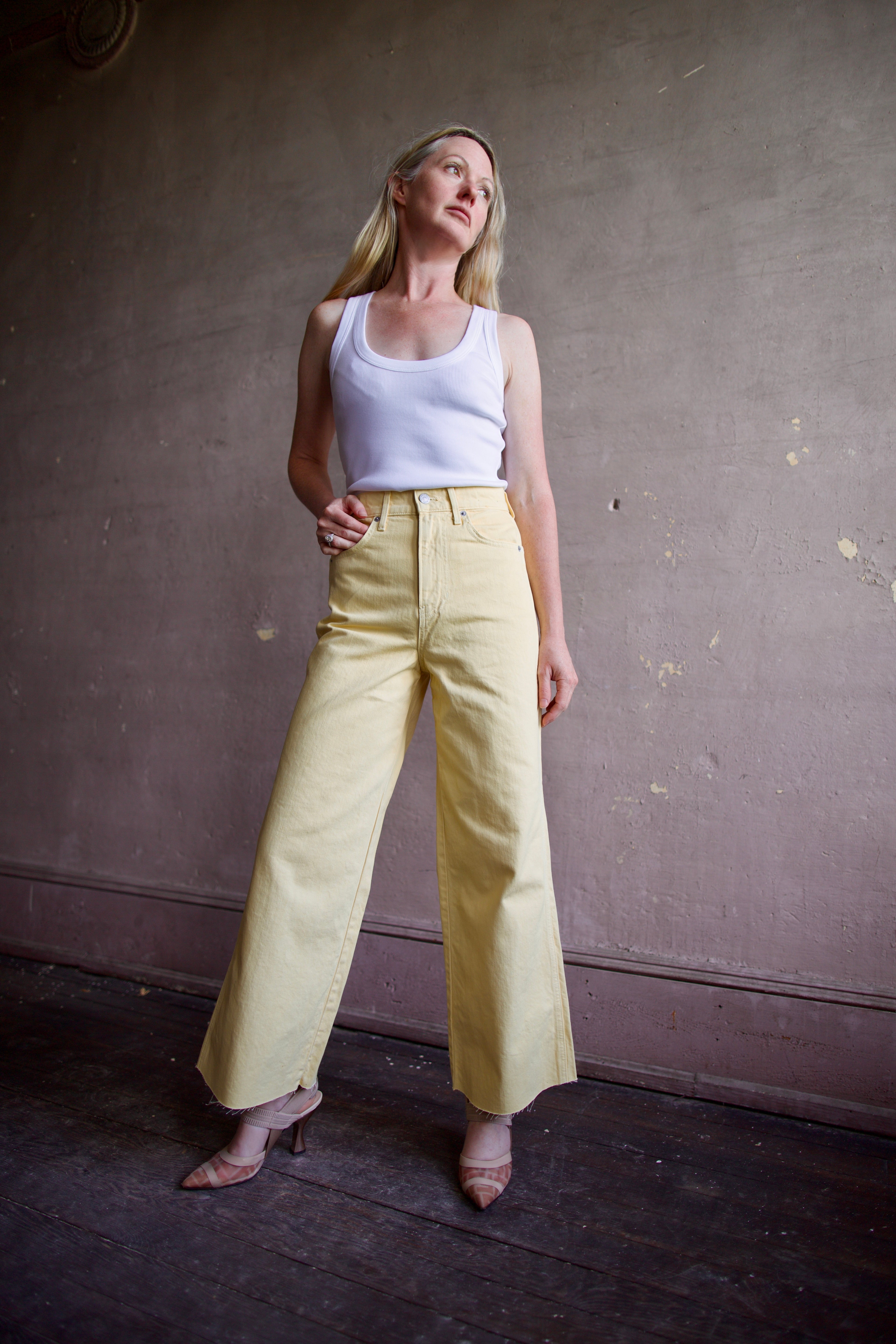 Mature woman wearing designer Veronica Beard butter yellow high rise crop taylor rigid 100% cotton denim jean with wide leg and made in USA