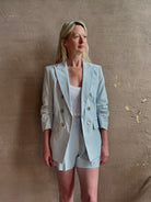 Mature woman wearing tailored Veronica Beard Tomi Dickey Jacket light blue cotton viscose blend ruched sleeves 