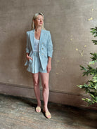 Mature woman wearing tailored Veronica Beard Tomi Dickey Jacket light blue ruched 3/4 sleeves cupro lining