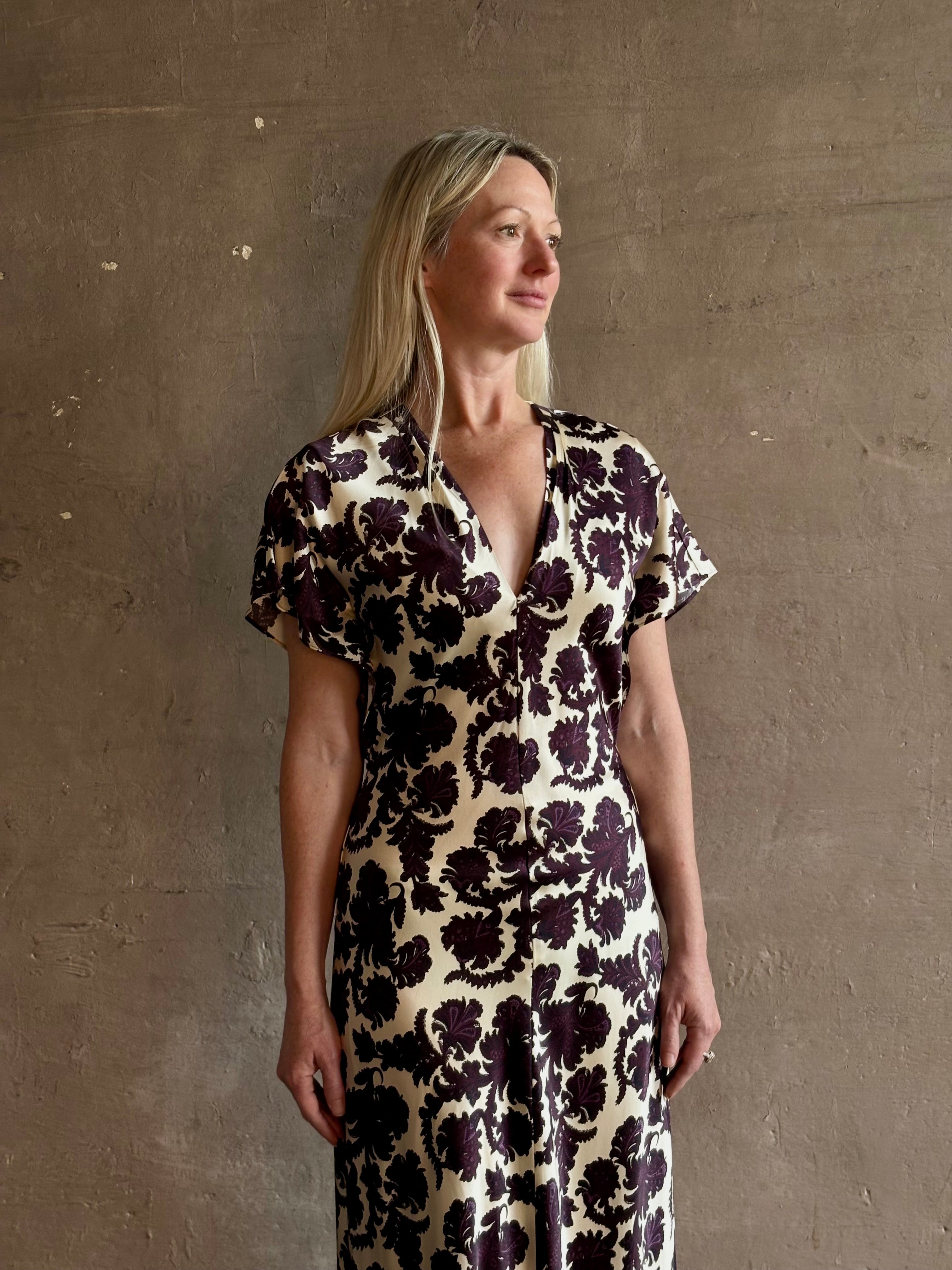 Mature woman wearing designer Veronica Beard V-Neck Redgrave Dress in Ecru Multi sheath maxi with a rich purple floral print Elongating, occasion-ready 