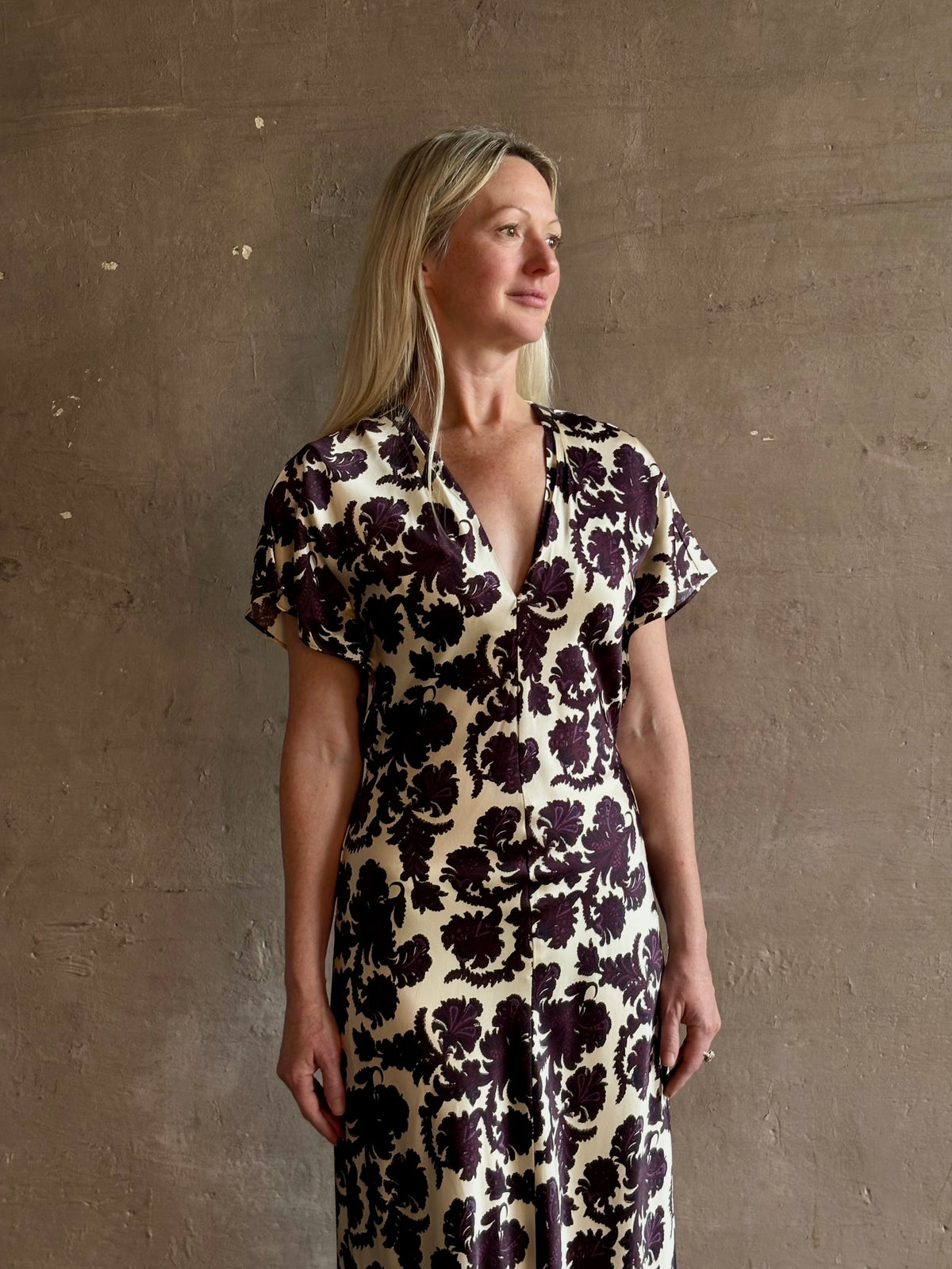Mature woman wearing designer Veronica Beard V-Neck Redgrave Dress in Ecru Multi sheath maxi with a rich purple floral print Elongating, occasion-ready 