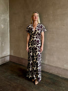 Mature woman wearing designer Veronica Beard V-Neck Redgrave Dress in Ecru Multi sheath maxi purple floral print Elongating, occasion-ready 