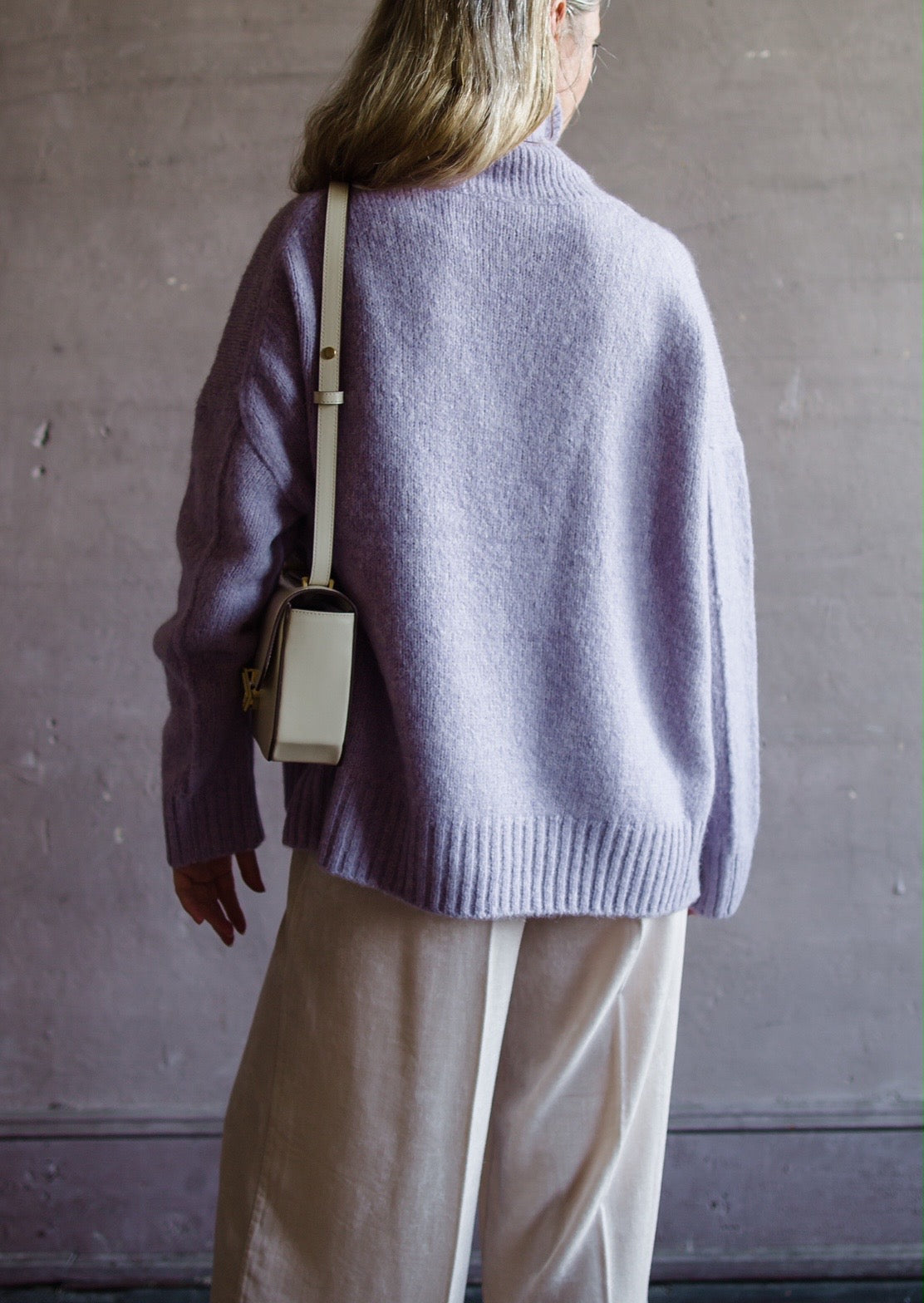 Image featuring a woman wearing the Balade yack, alpaca & wool sweater by Vanessa Bruno with a high neckline with a front seam and oversized fit in lilac color.