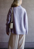 Image featuring a woman wearing the Balade yack, alpaca & wool sweater by Vanessa Bruno with a high neckline with a front seam and oversized fit in lilac color.