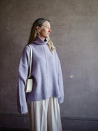 Image featuring a woman wearing the Balade yack, alpaca & wool sweater by Vanessa Bruno with a high neckline with a front seam and oversized fit in lilac color.