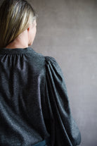 Close up back view of woman wearing Vanessa Bruno bell poet blouse in anthracite gray wool blend