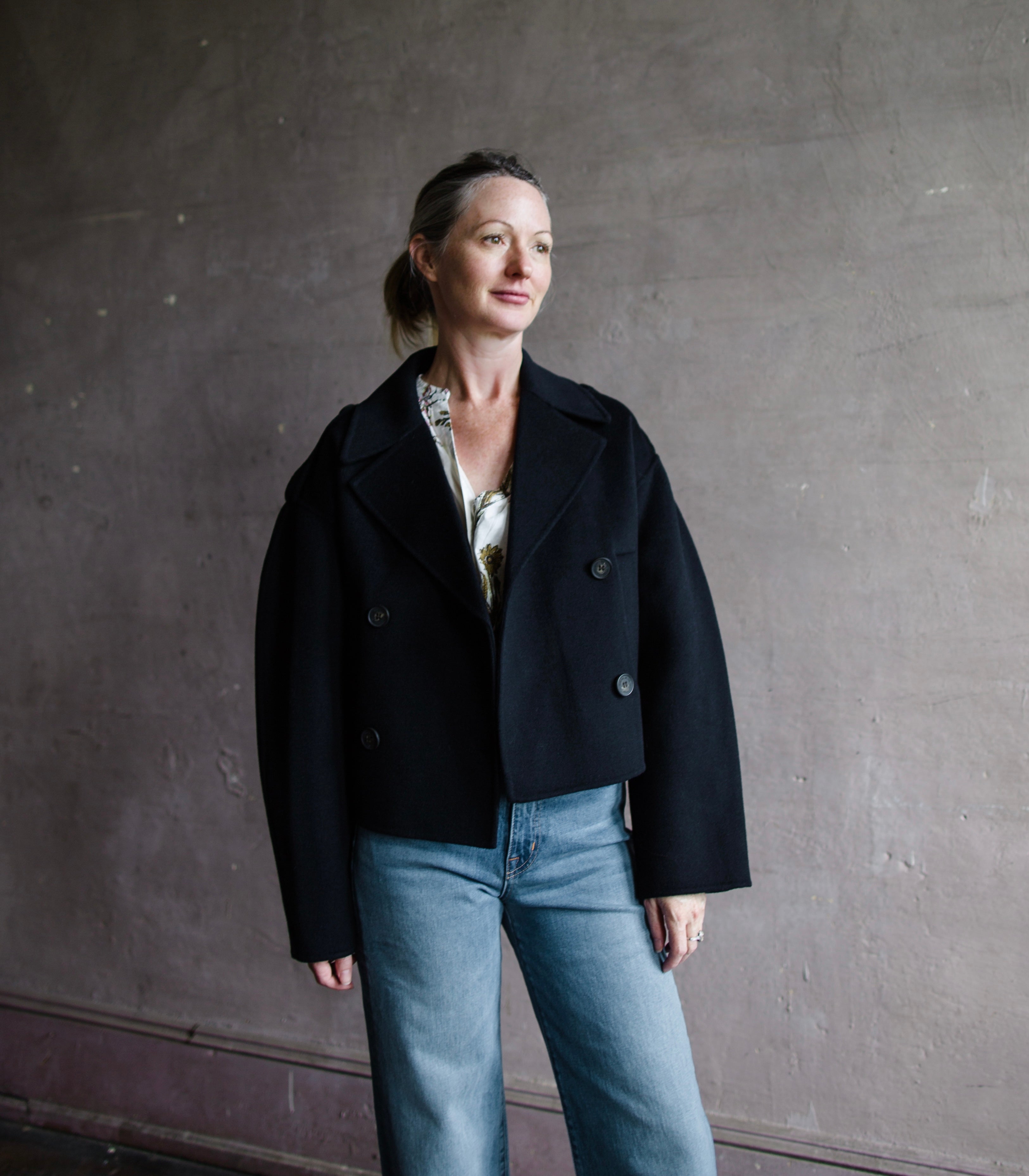 Image featuring a woman wearing the Beran jacket by Vanessa Bruno with double breasted button closure and a full sleeve with a slightly shorter fit in navy blue.