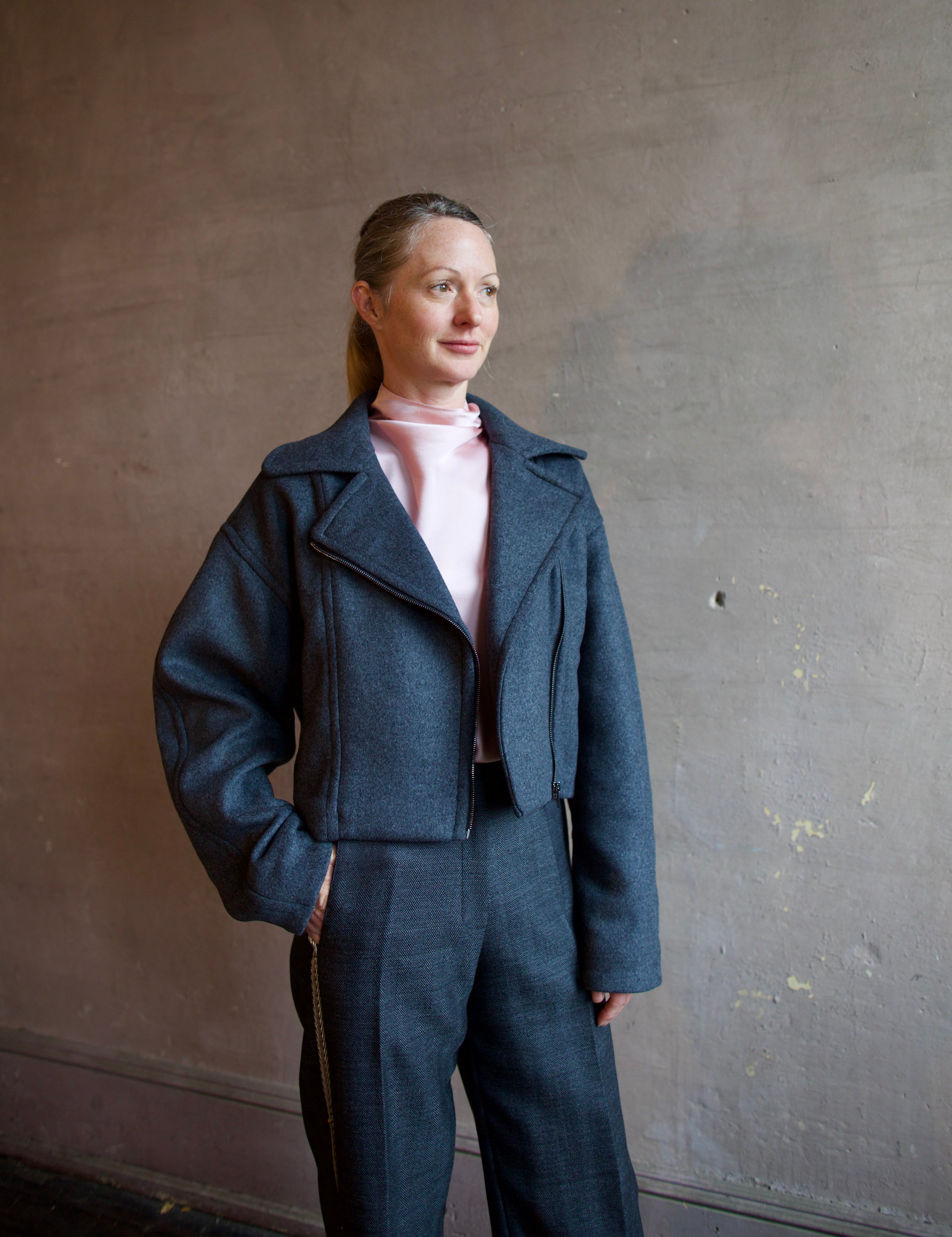 Image featuring a woman wearing the Bless jacket by Vanessa Bruno with an asymmetrical zipper, full sleeve and a slightly cropped fit in dark grey.