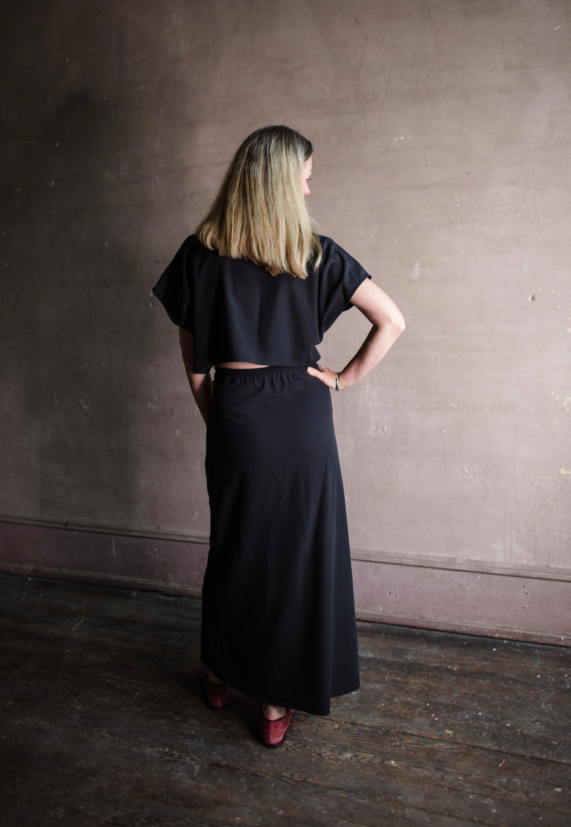 Image featuring a woman wearing the Cheryle dress by Vanessa Bruno  in lyocell with a button front and tailored skirting with an open back in navy blue colorway.