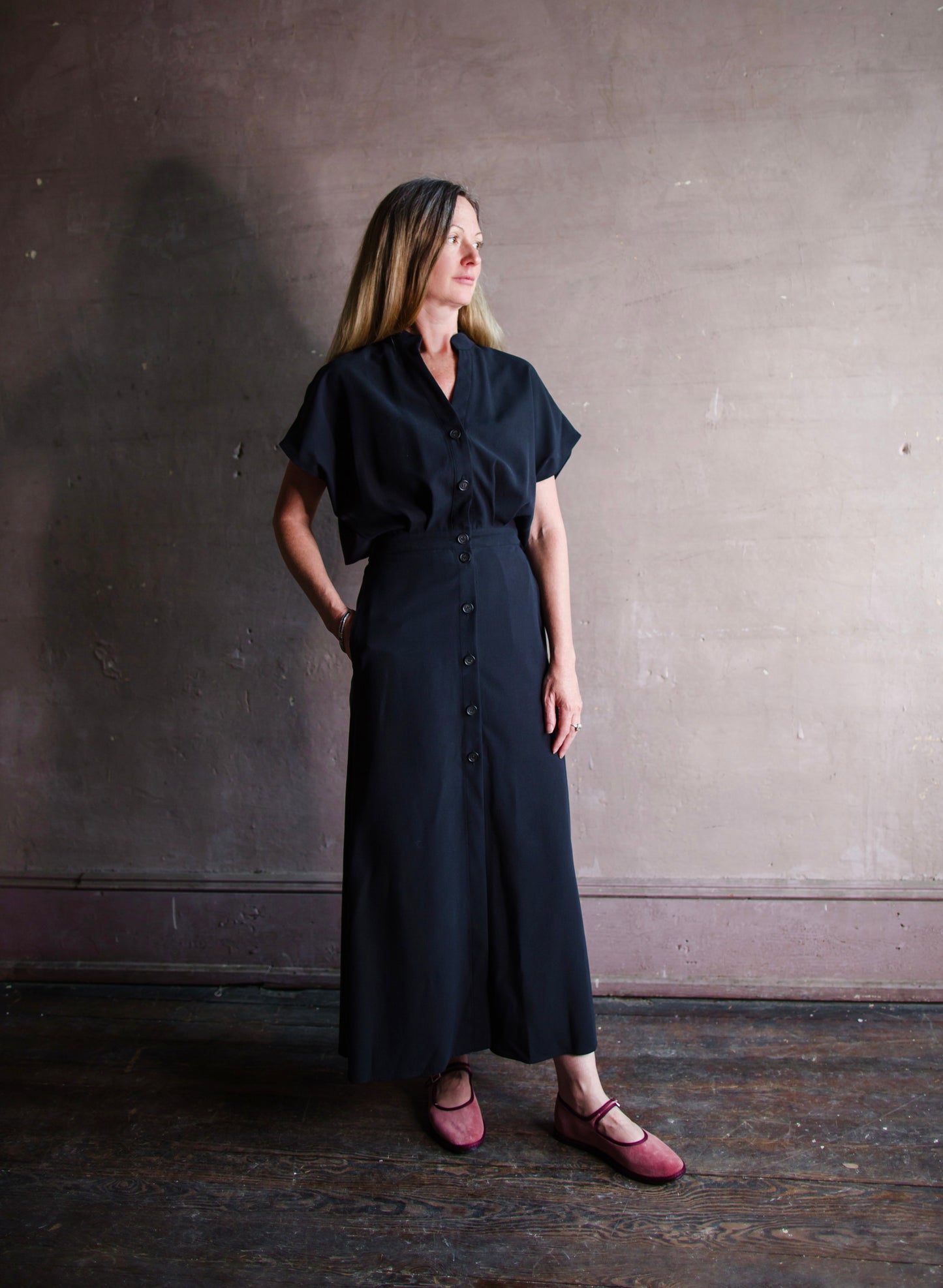 Image featuring a woman wearing the Cheryle dress by Vanessa Bruno  in lyocell with a button front and tailored skirting with an open back in navy blue colorway.