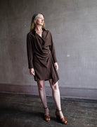 Image featuring a woman wearing the brown Demi wrap dress by Vanessa Bruno with long sleeves, a button front and wrap styling mini dress in a silk blend.