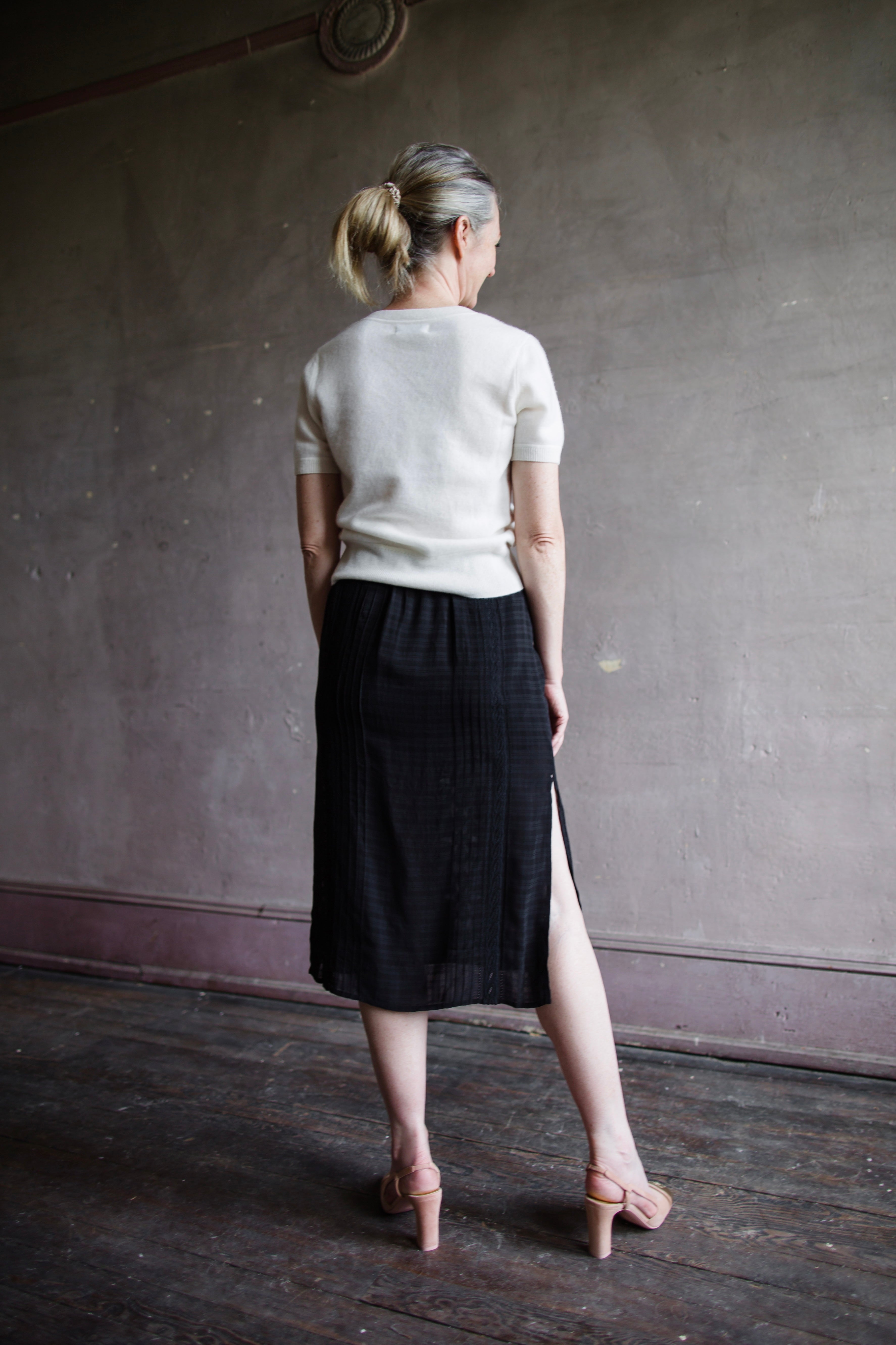 Image featuring a woman wearing the Dori skirt by Vanessa Bruno with a semi-sheer jacquard viscose textured and layered fit, side slits and an elastic waist in black.