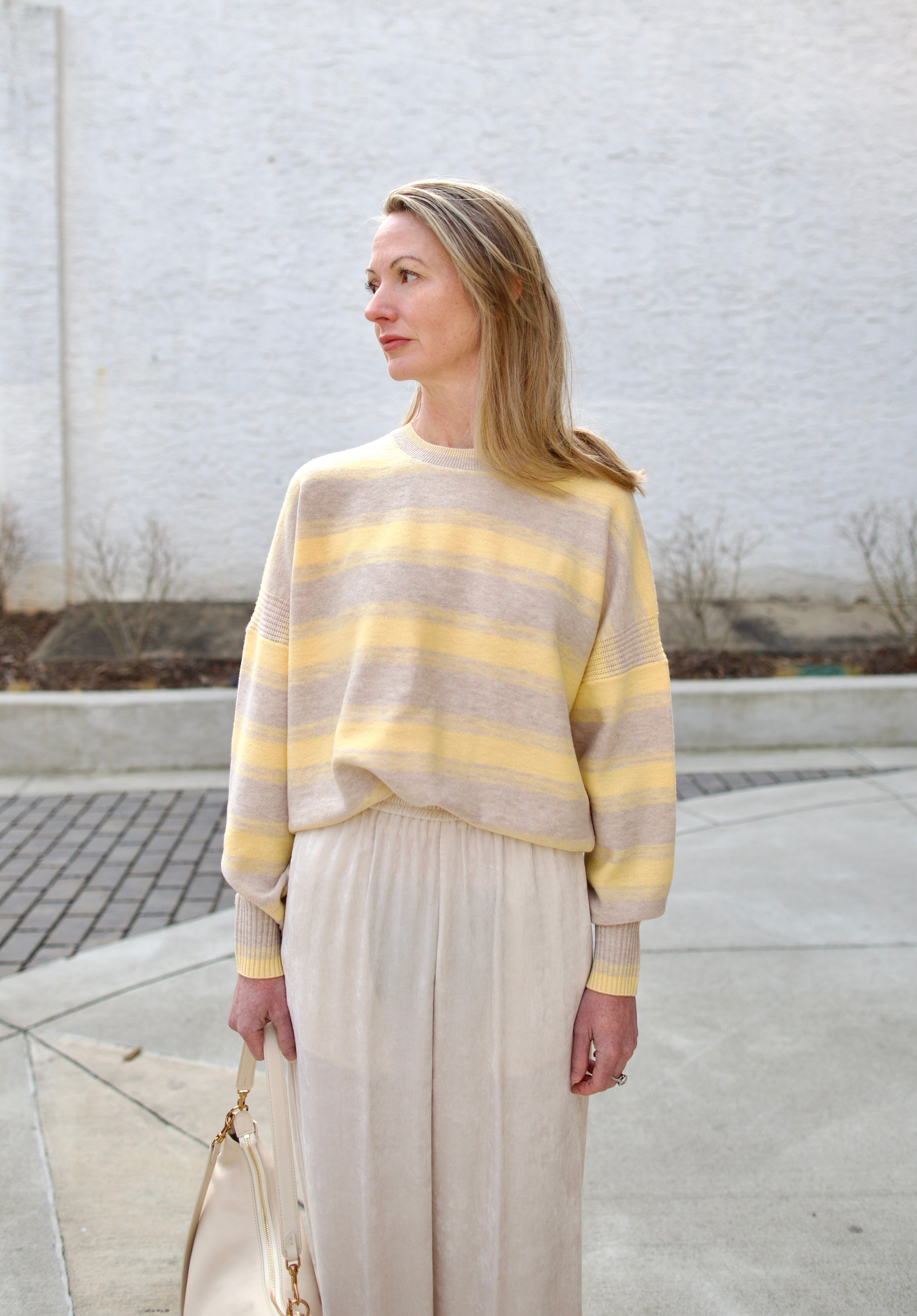 image of a woman wearing the vanessa bruno eugenie striped sweater, forte forte corduroy pants and mansur gavriel swing bag