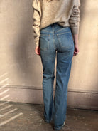 Close up back image of woman wearing Vanessa Bruno Benito high rise jeans with straight leg full length medium wash V detail and two patch pockets