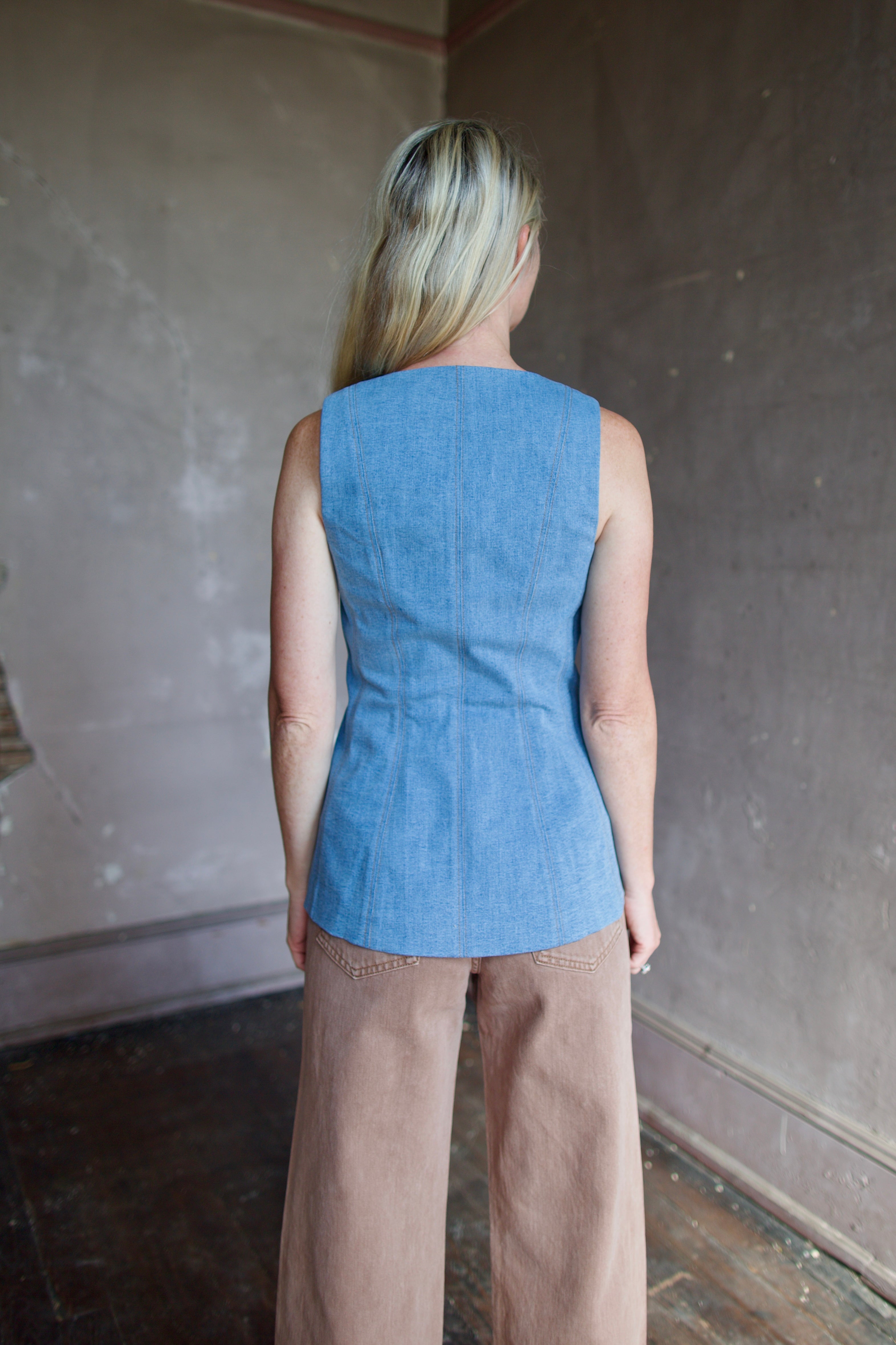Model wearing designer Veronica Beard Avalina Vest in Blue Mirage with expert tayloring brown thread seams