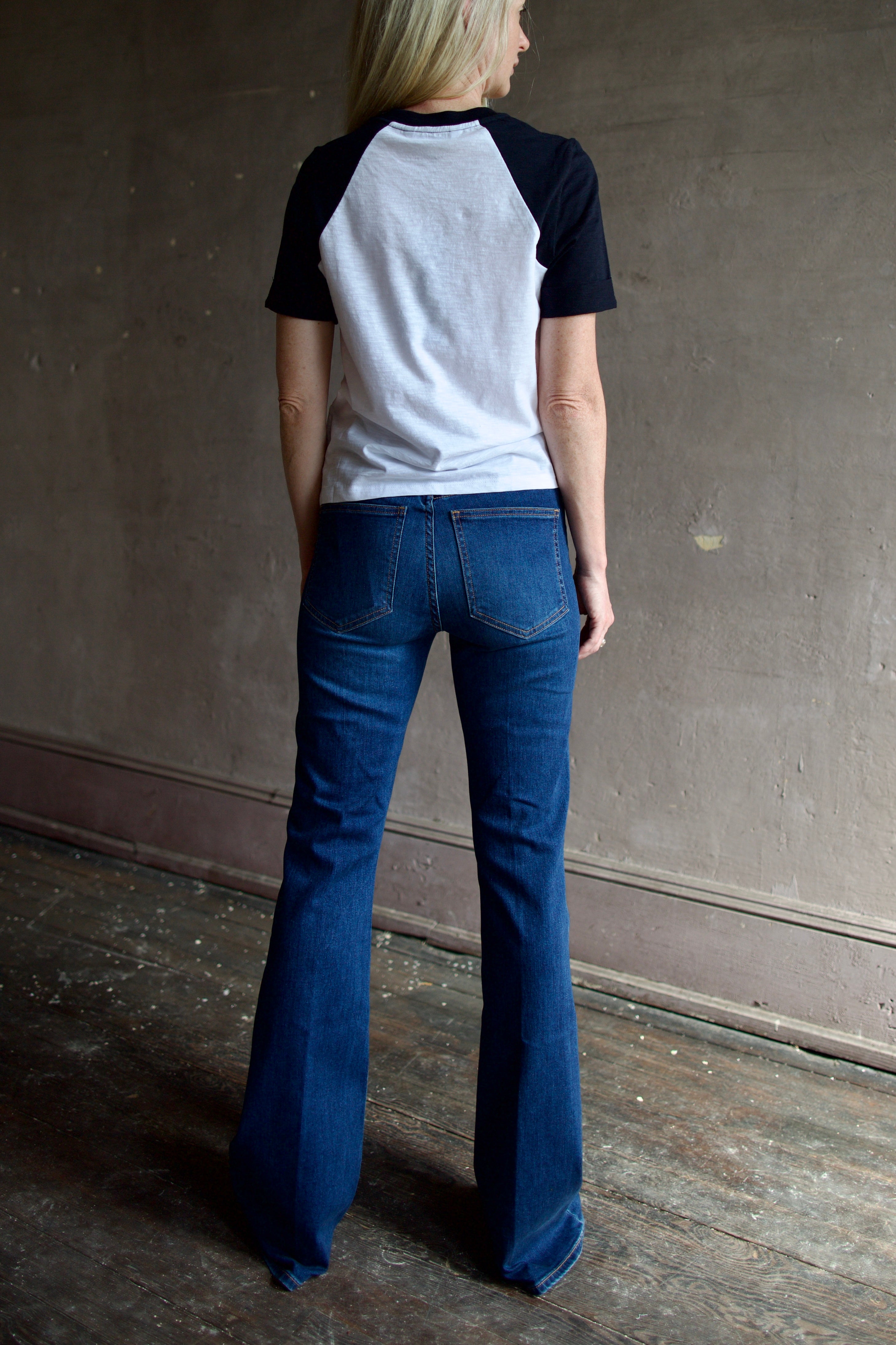 Model wearing premium designer denim by Veronica Beard  Beverly High Rise flared boot-cut full length jeans in stretchy cotton blend