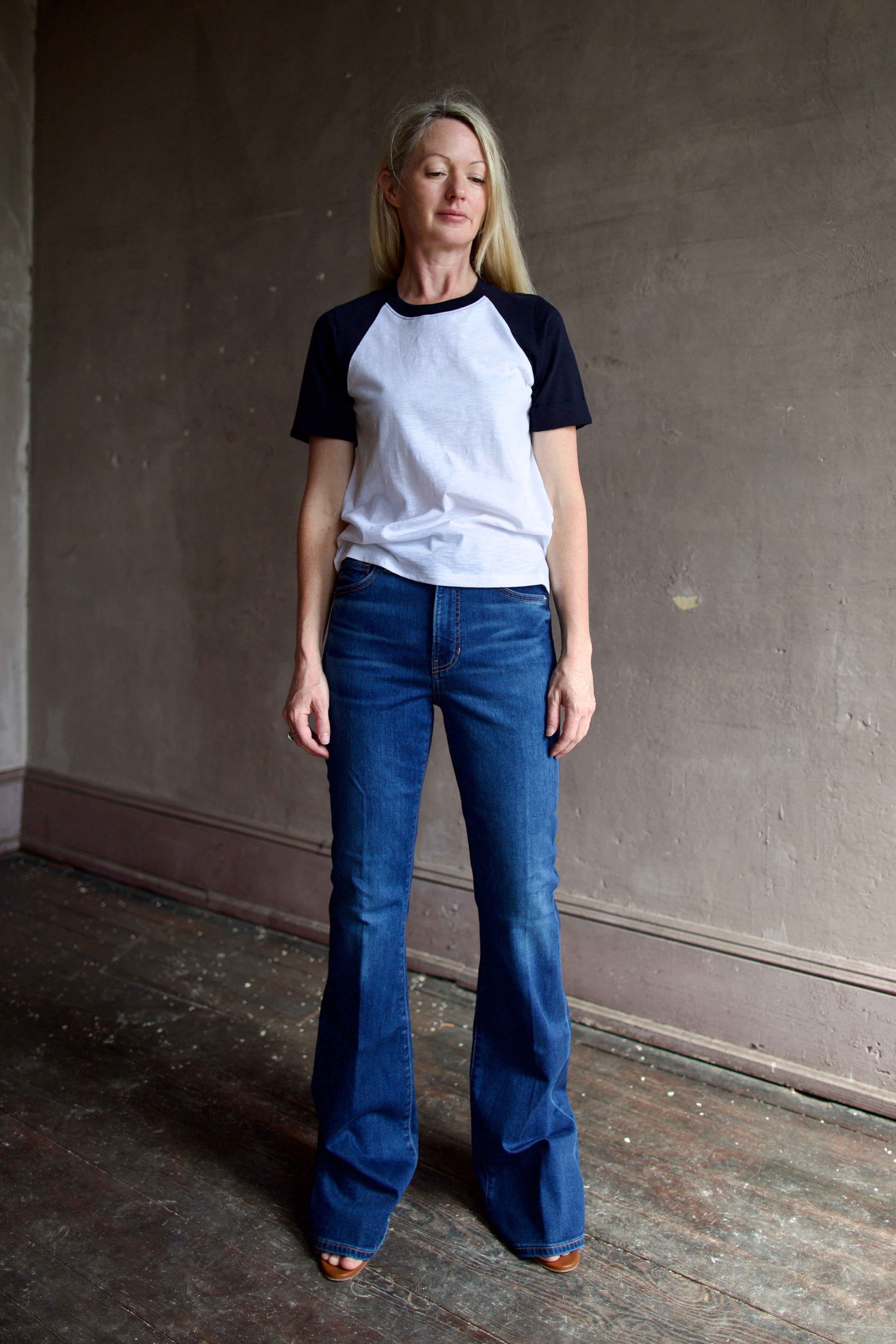 Model wearing premium designer denim by Veronica Beard  Beverly High Rise flared boot-cut full length jeans in stretchy cotton blend