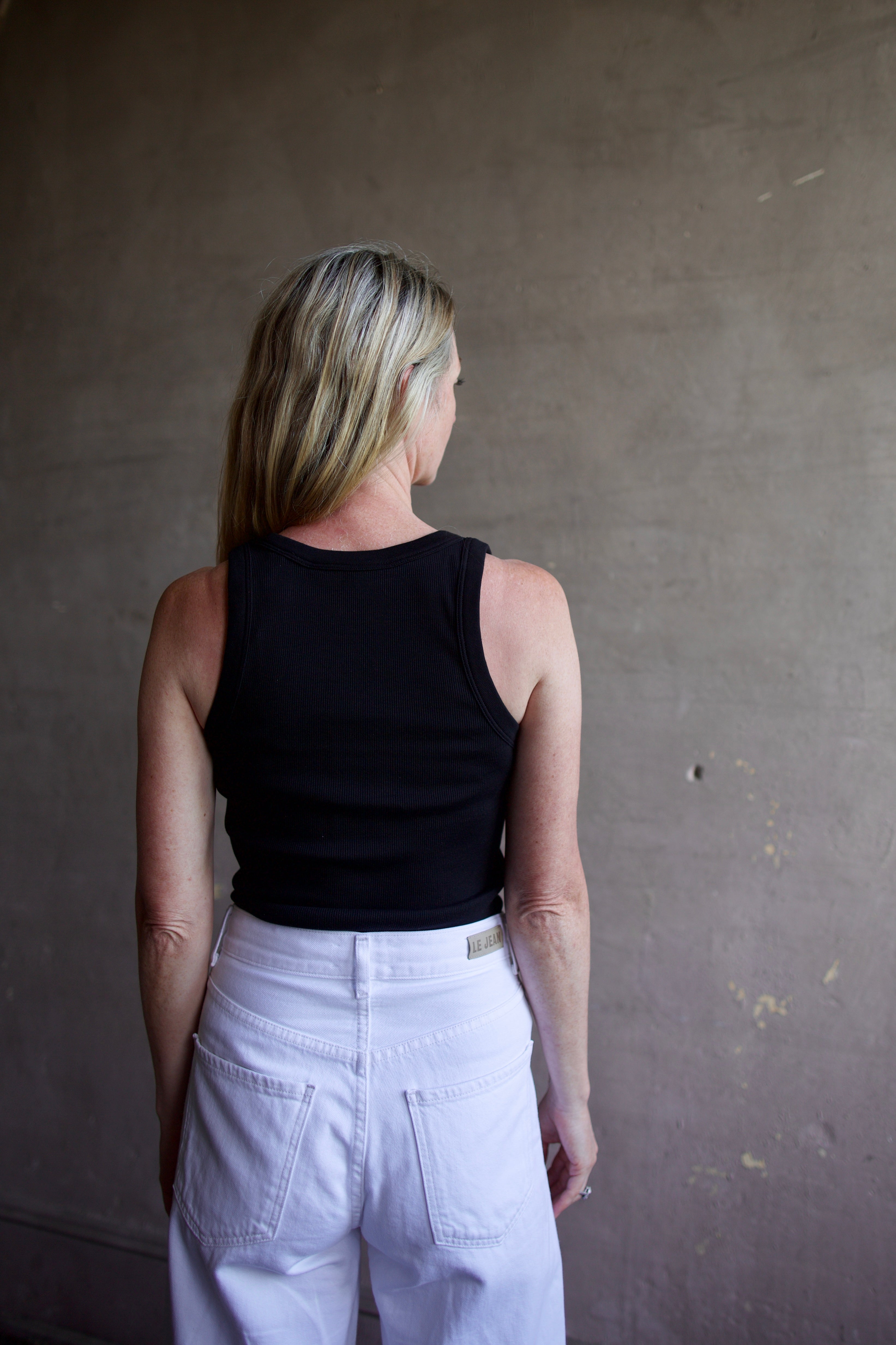 Image of a model wearing designer Veronica Beard Birke black tank top in premium cotton blend with ribbed texture and classic scoop neckline