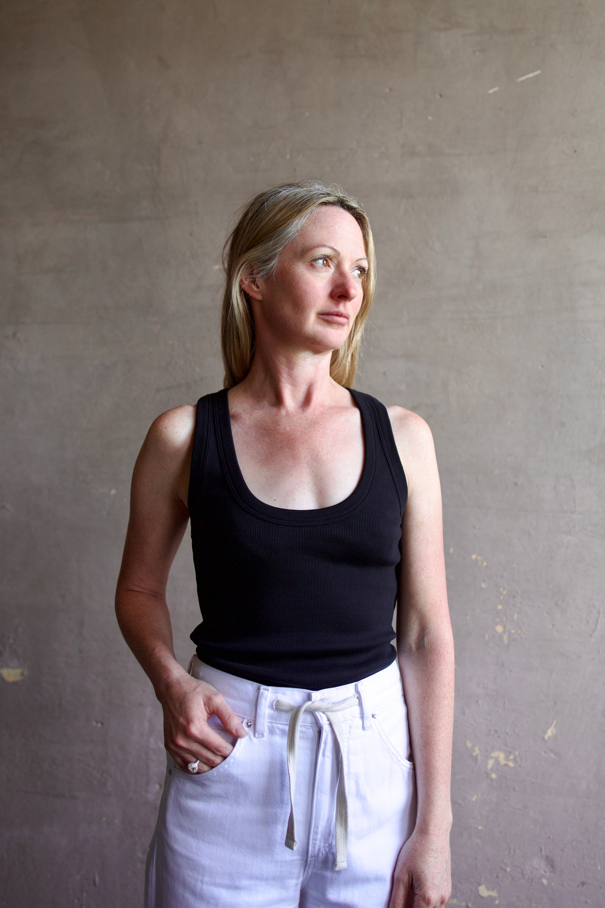 Image of a model wearing designer Veronica Beard Birke black tank top in premium cotton blend with ribbed texture and classic scoop neckline