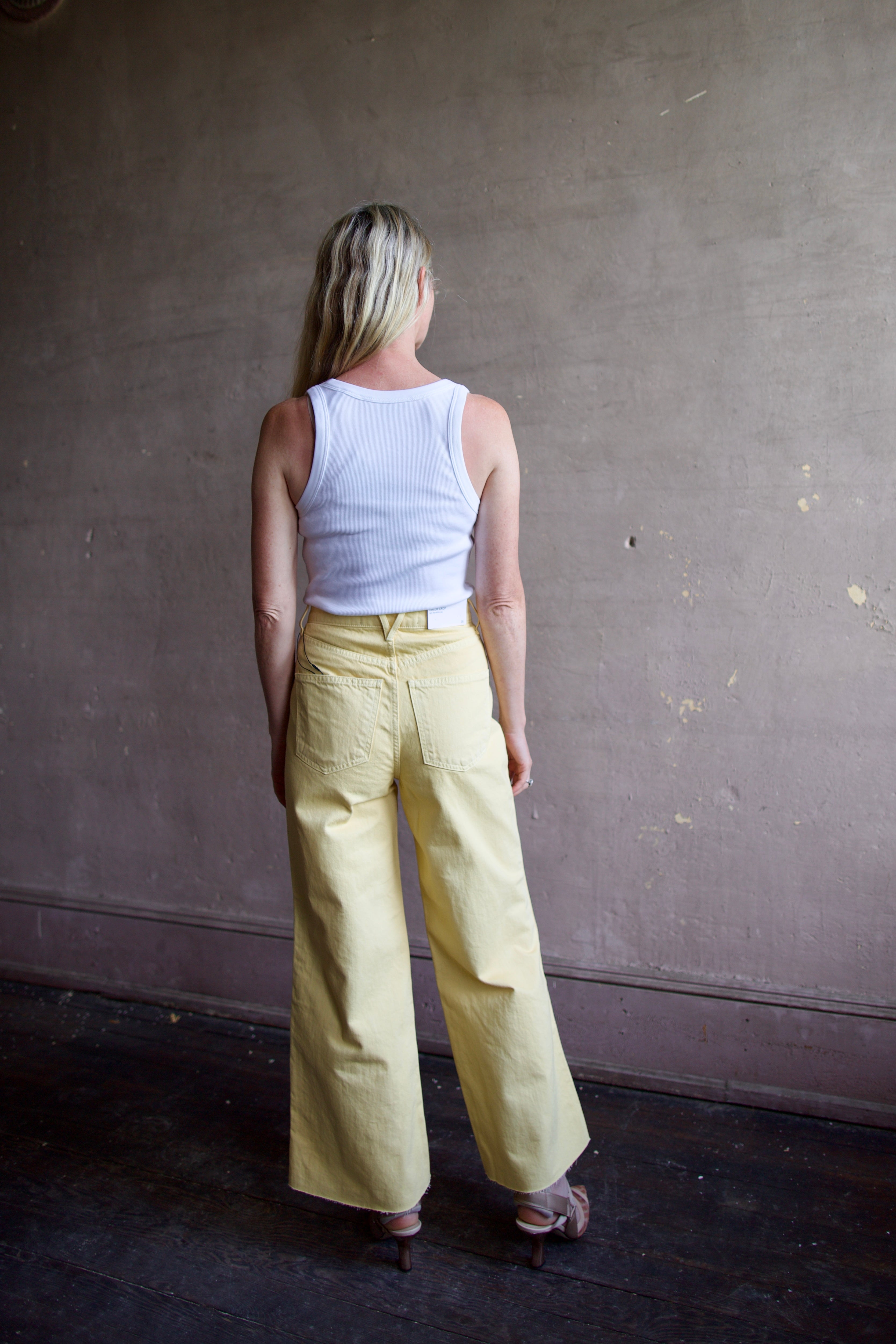 Image of a model wearing designer Veronica Beard butter yellow high rise crop taylor denim
