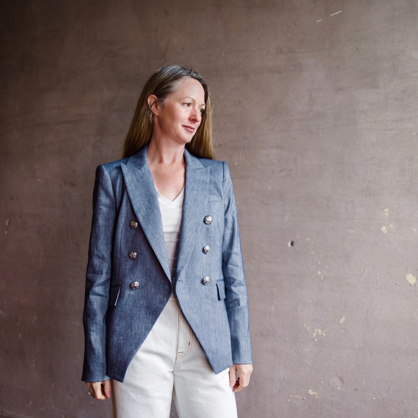 Image featuring a woman wearing the Miller stretch-linen blend blazer by Veronica Beard with silver crest buttons give the jacket a polished finish. 