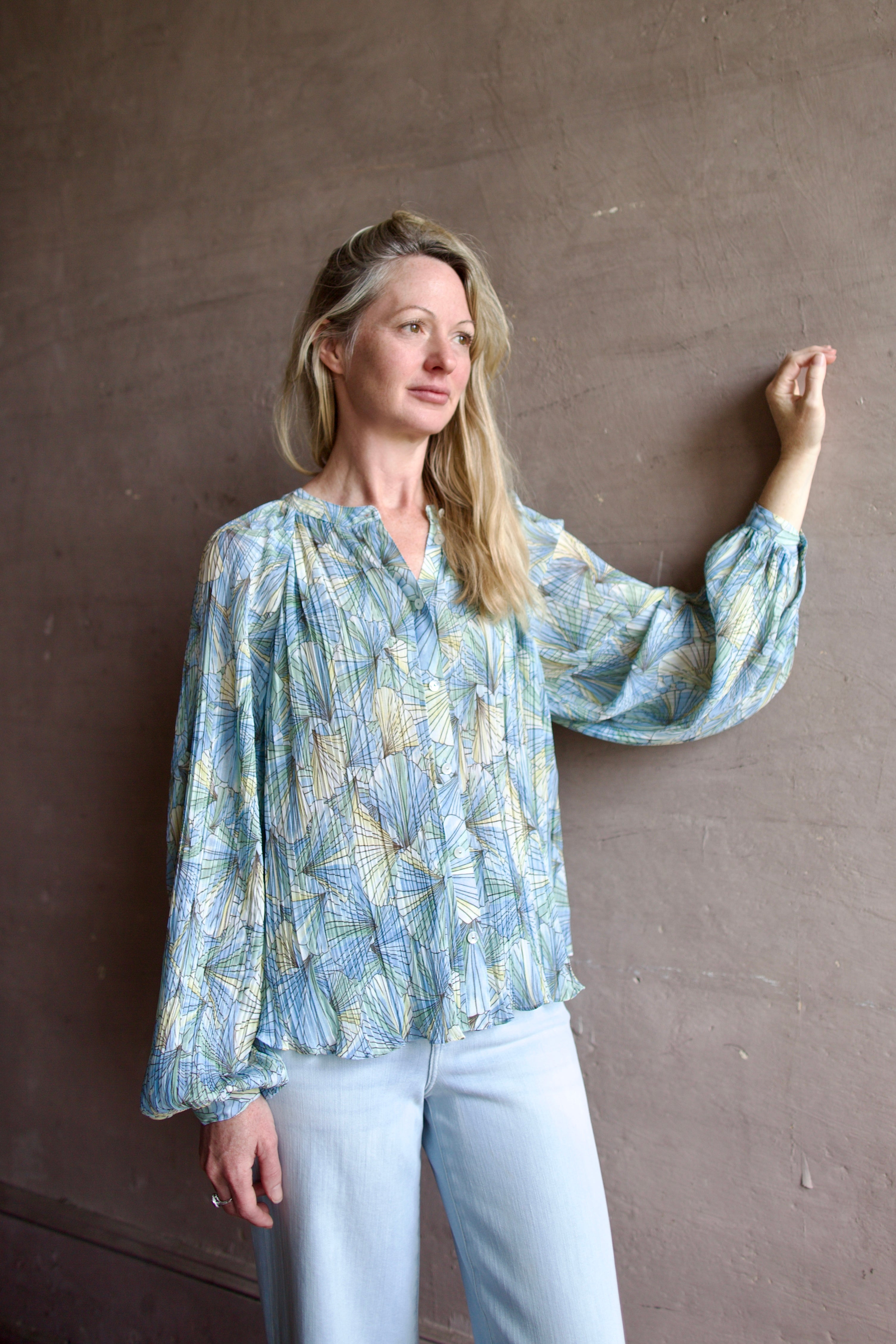 Mature womanl wearing designer Veronica Beard Fennel Pleated Blouse with long sleeve in flowy effortless Bohemian style made in USA