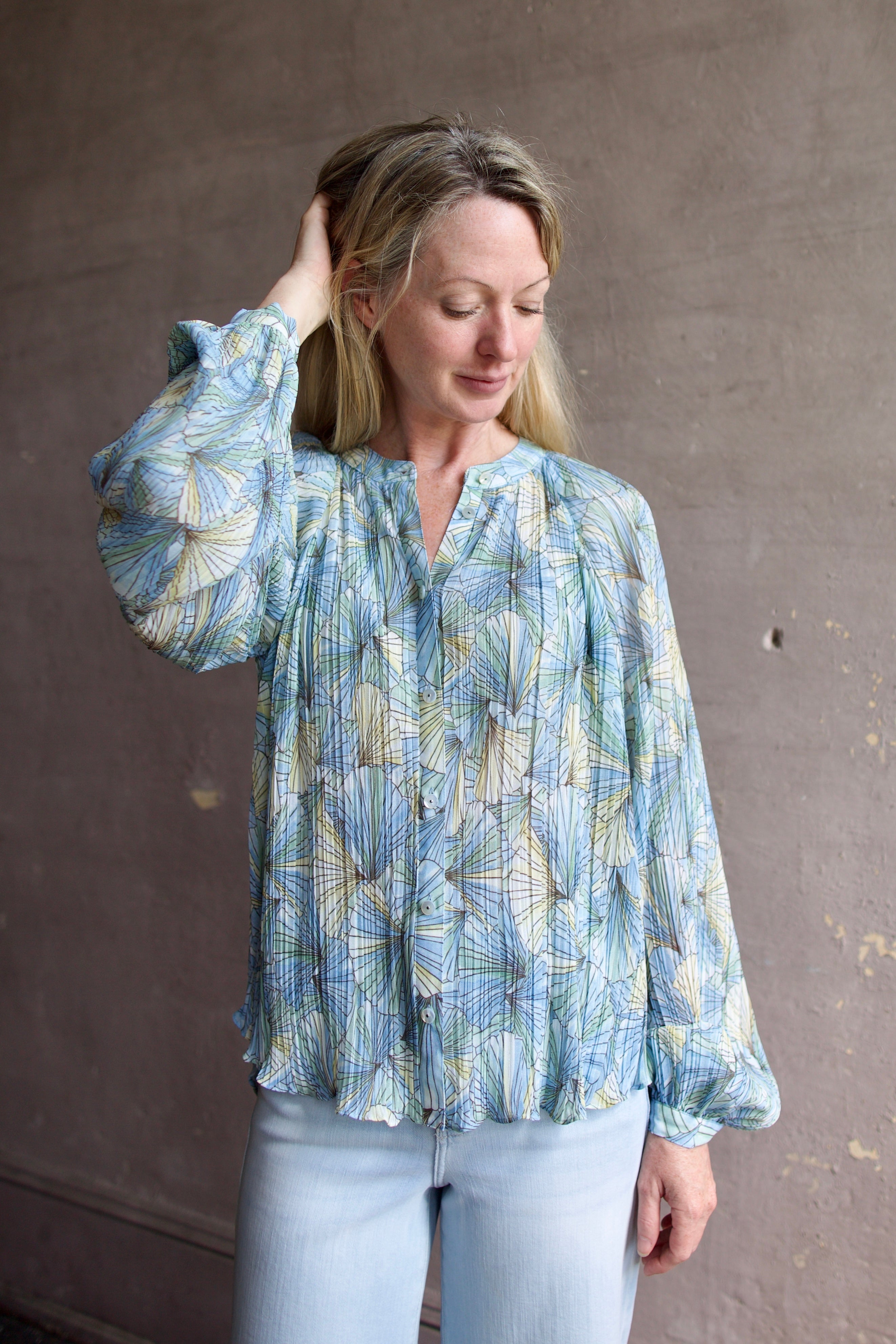 Mature womanl wearing designer Veronica Beard Fennel Pleated Blouse with long sleeve in flowy effortless Bohemian style and wrinkle free perfect to pack for vacation