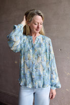 Mature womanl wearing designer Veronica Beard Fennel Pleated Blouse with long sleeve in flowy effortless Bohemian style and wrinkle free perfect to pack for vacation