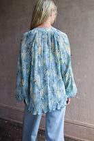 Mature womanl wearing designer Veronica Beard Fennel Pleated Blouse with long sleeve in flowy effortless Bohemian style and wrinkle free perfect to pack for vacation