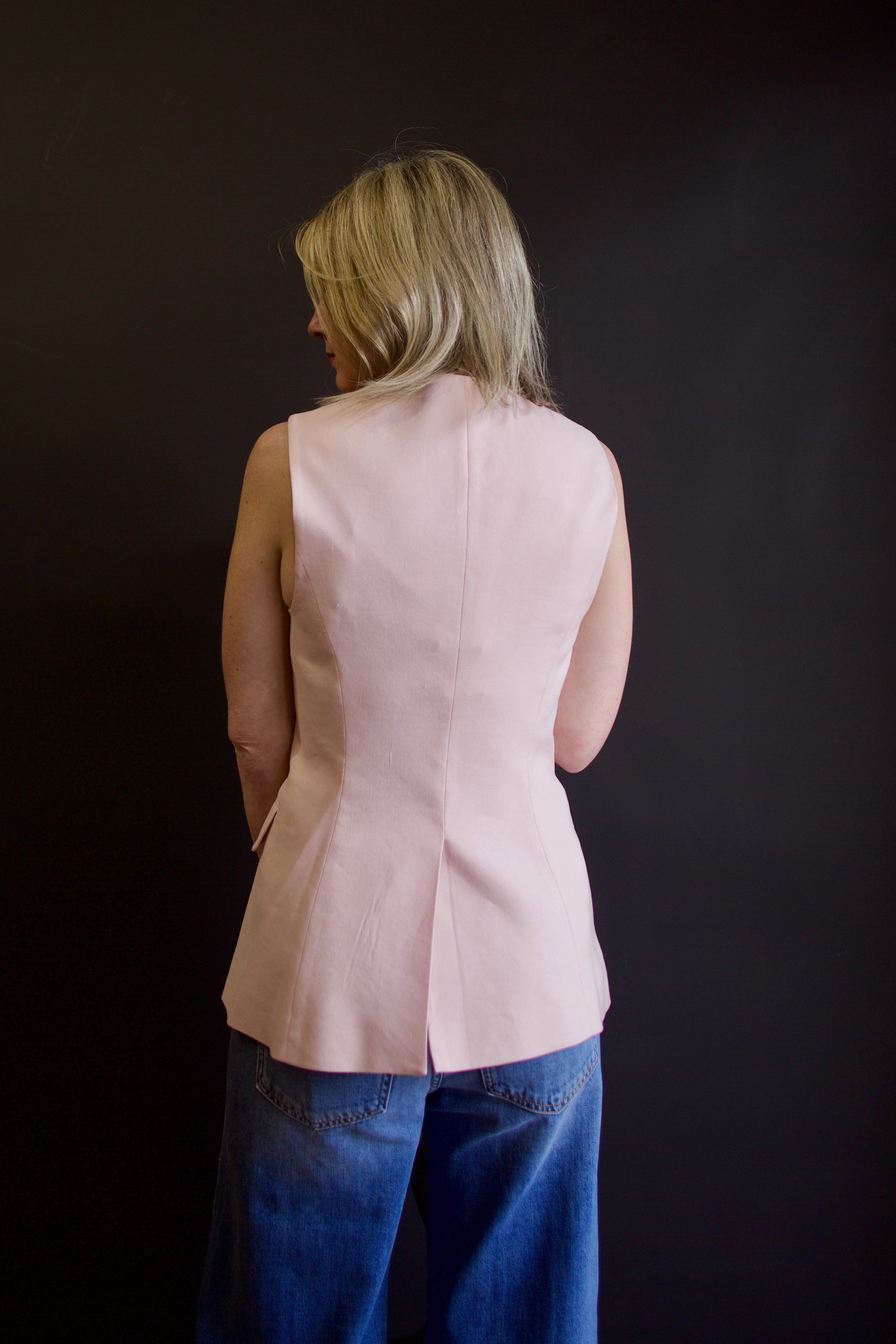 Mature woman wearing Veronica Beard Lois Vest in shell pink with center seam and back vent for comport fit 