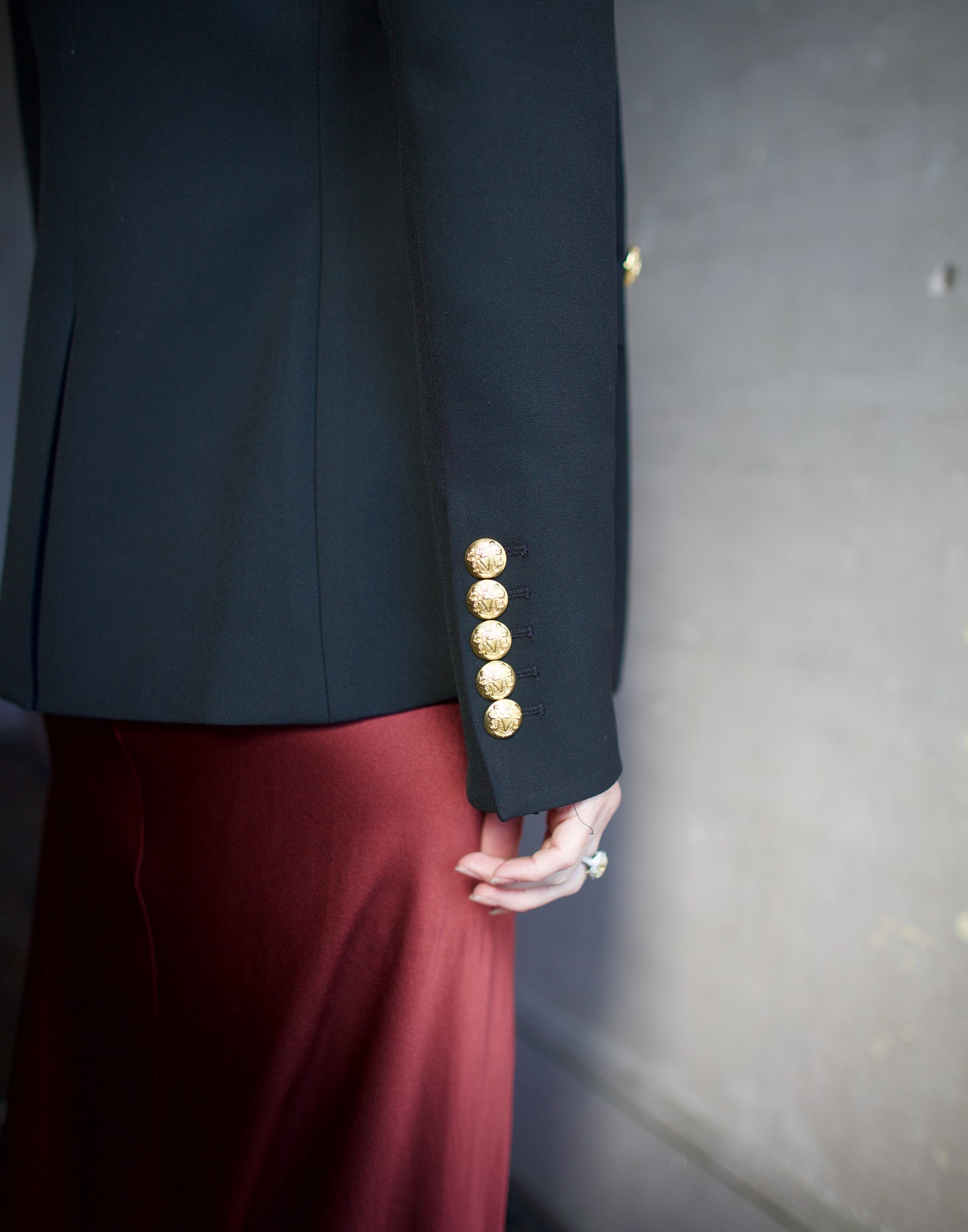 Image featuring a woman wearing the Miller Dickey Jacket by Veronica Beard with a double breasted closure and tailored fit in black with gold color buttons.