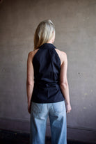 Mature woman wearing luxury women's black cotton blend Veronica Beard Regina Shirt with button front, collar, sleeveless, and tailored fit