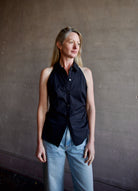 Mature woman wearing luxury women's black cotton blend Veronica Beard Regina Shirt with button front, collar, sleeveless, and tailored fit