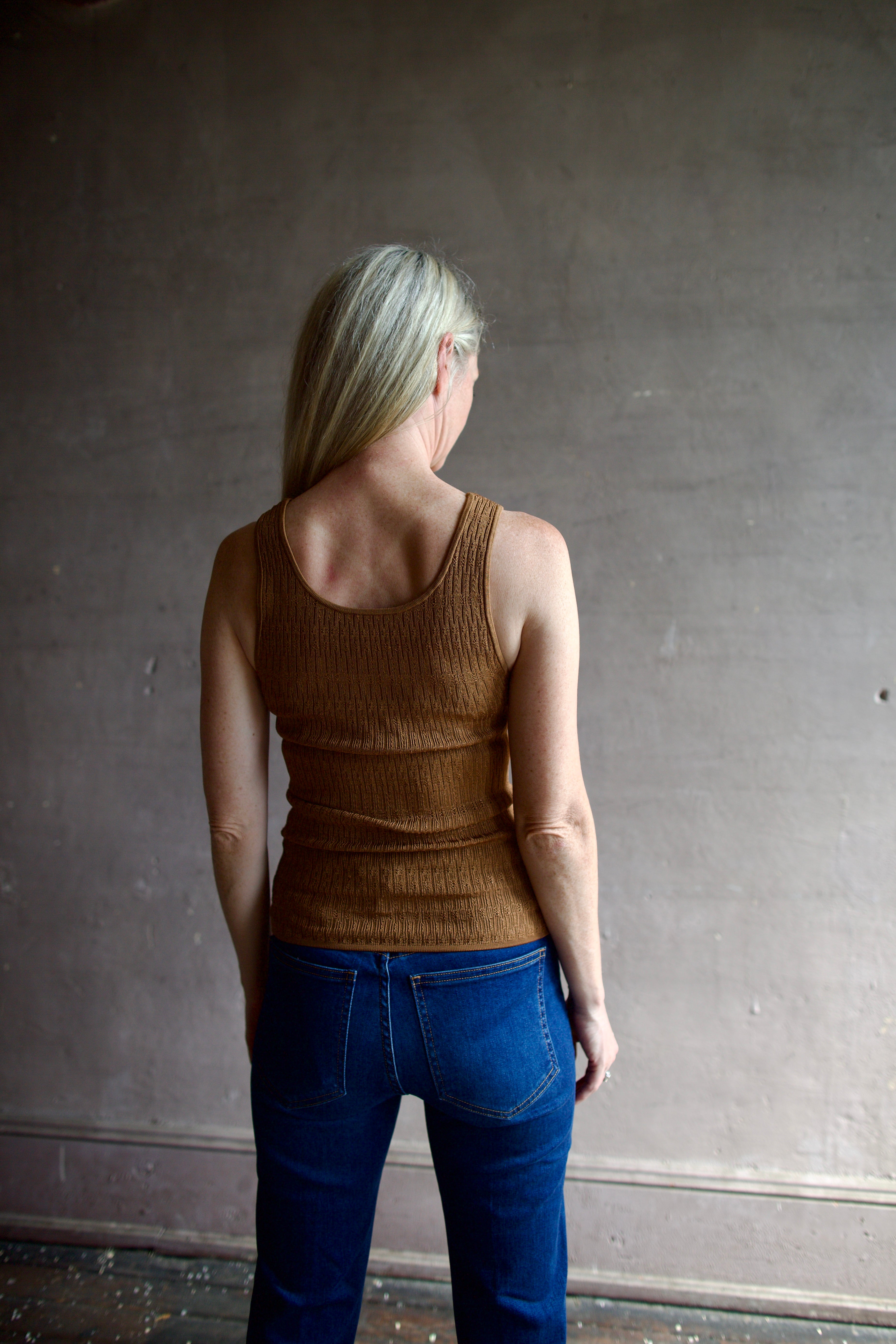 Model wearing premium  designer Veronica  Beard Sandra Tank with quality texture and scoop neck in a neutral copper colorway