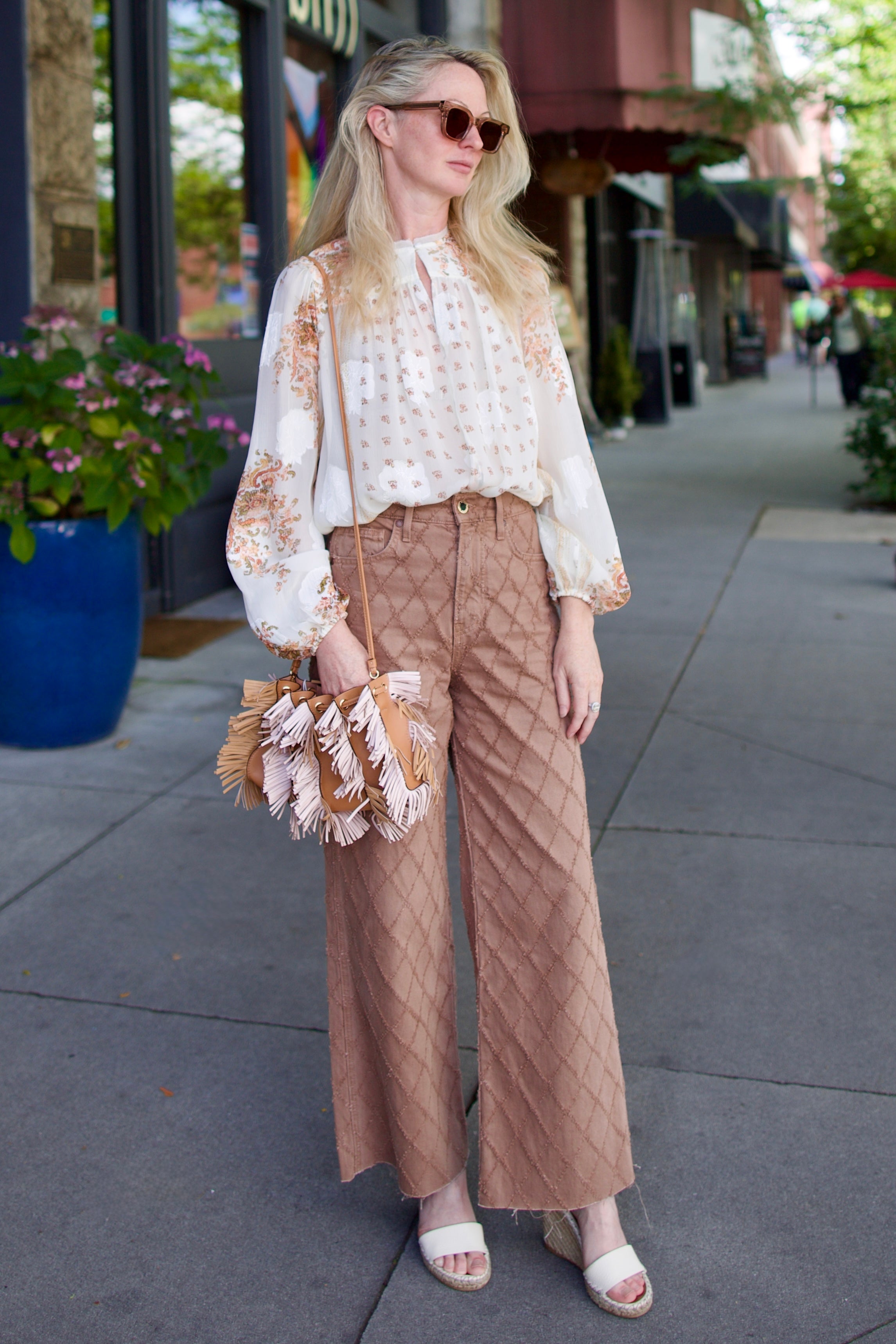 image of a woman wearing the Veronica Beard Taylor Cropped Jeans in Hazelnut Stone and Ulla Johnson Aster Blouse and Fringe Handbag
