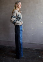 Image featuring a woman wearing the Taylor jeans by Veronica Beard with a high rise, wide leg and a two tone wash. Fabricated in blue denim front and black denim sides & back.