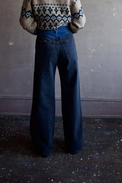 Image featuring a woman wearing the Taylor jeans by Veronica Beard with a high rise, wide leg and a two tone wash. Fabricated in blue denim front and black denim sides & back.