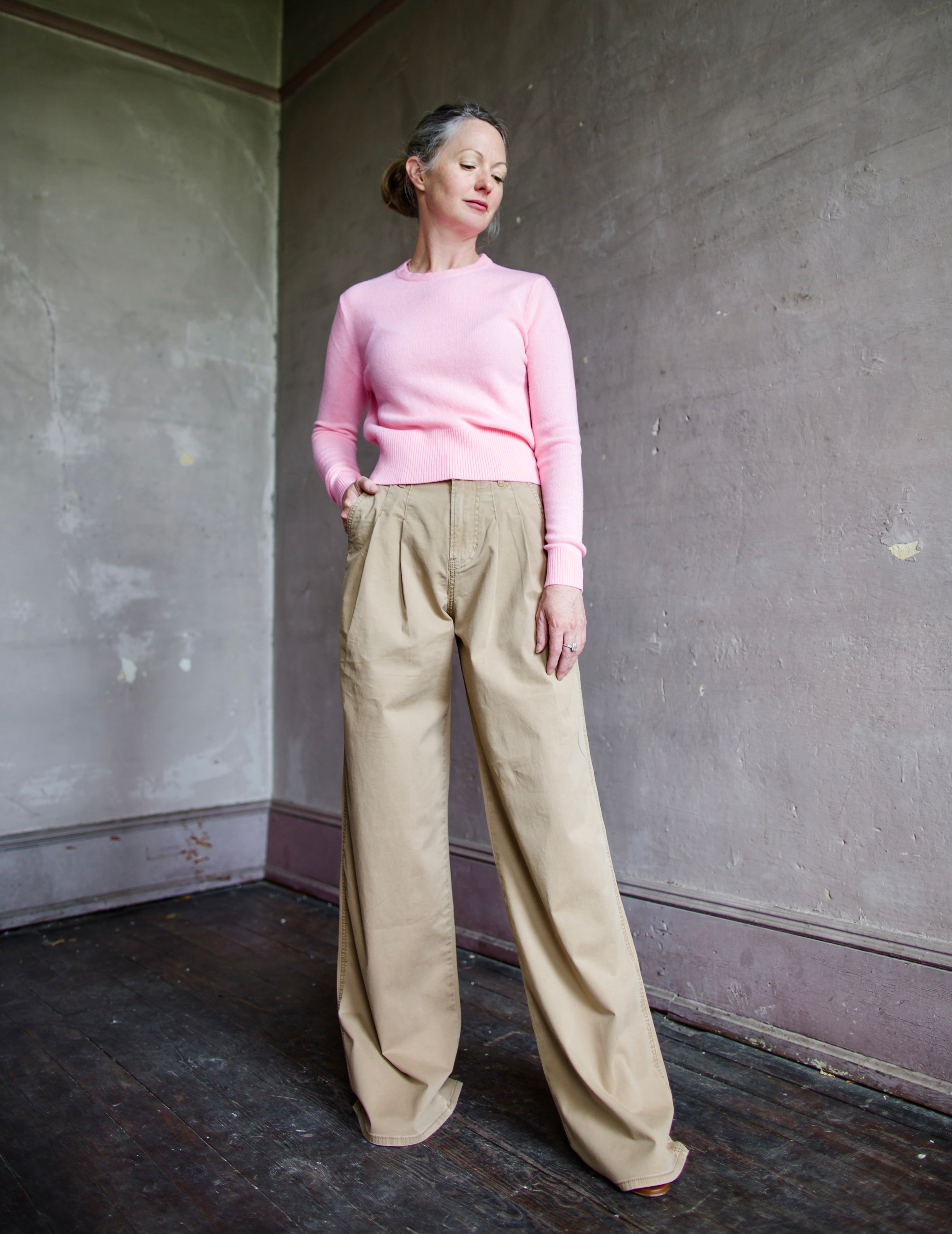 Image featuring a woman wearing the cotton blend Mia pants by Veronica Beard with a high rise, front pleats and a wide leg in Khaki.