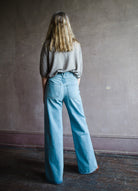 Image featuring a woman wearing the Taylor jeans by Veronica Beard fabricated in non-stretch Japanese denim with a high rise, wide leg and  seam detailing in Nova wash.