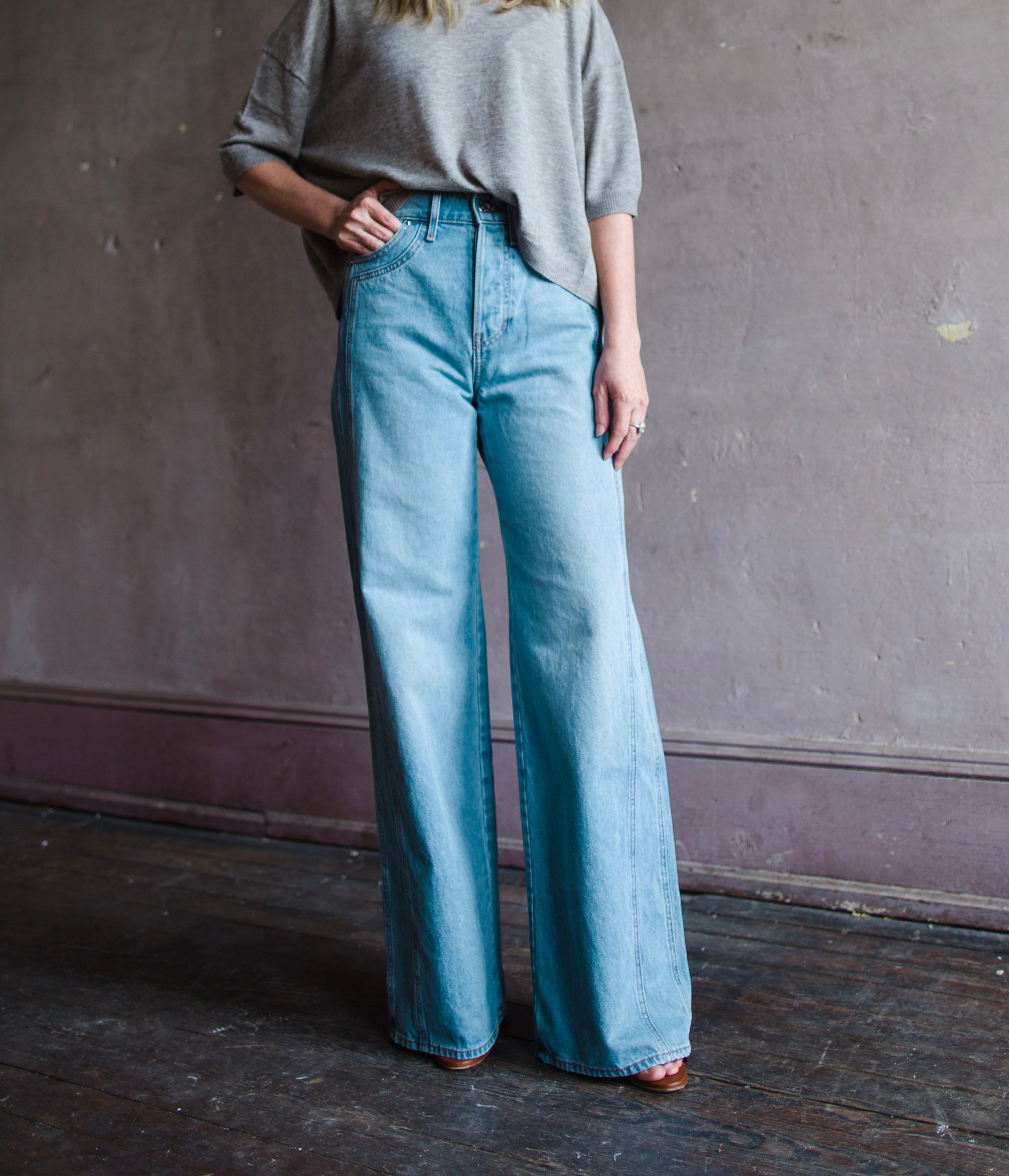 Image featuring a woman wearing the Taylor jeans by Veronica Beard fabricated in non-stretch Japanese denim with a high rise, wide leg and  seam detailing in Nova wash.