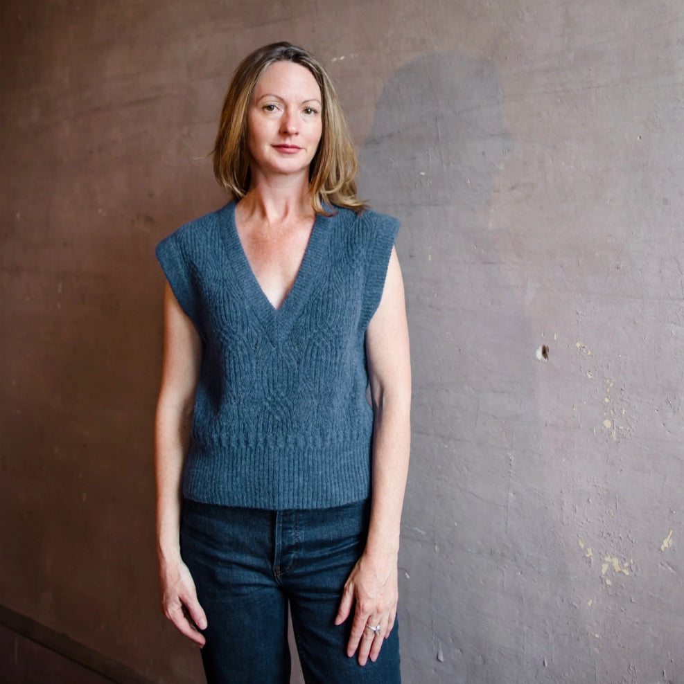 Image featuring a woman wearing the Veronica Beard Arida Knit Sweater Vest in a blue mixed pointelle stitch.