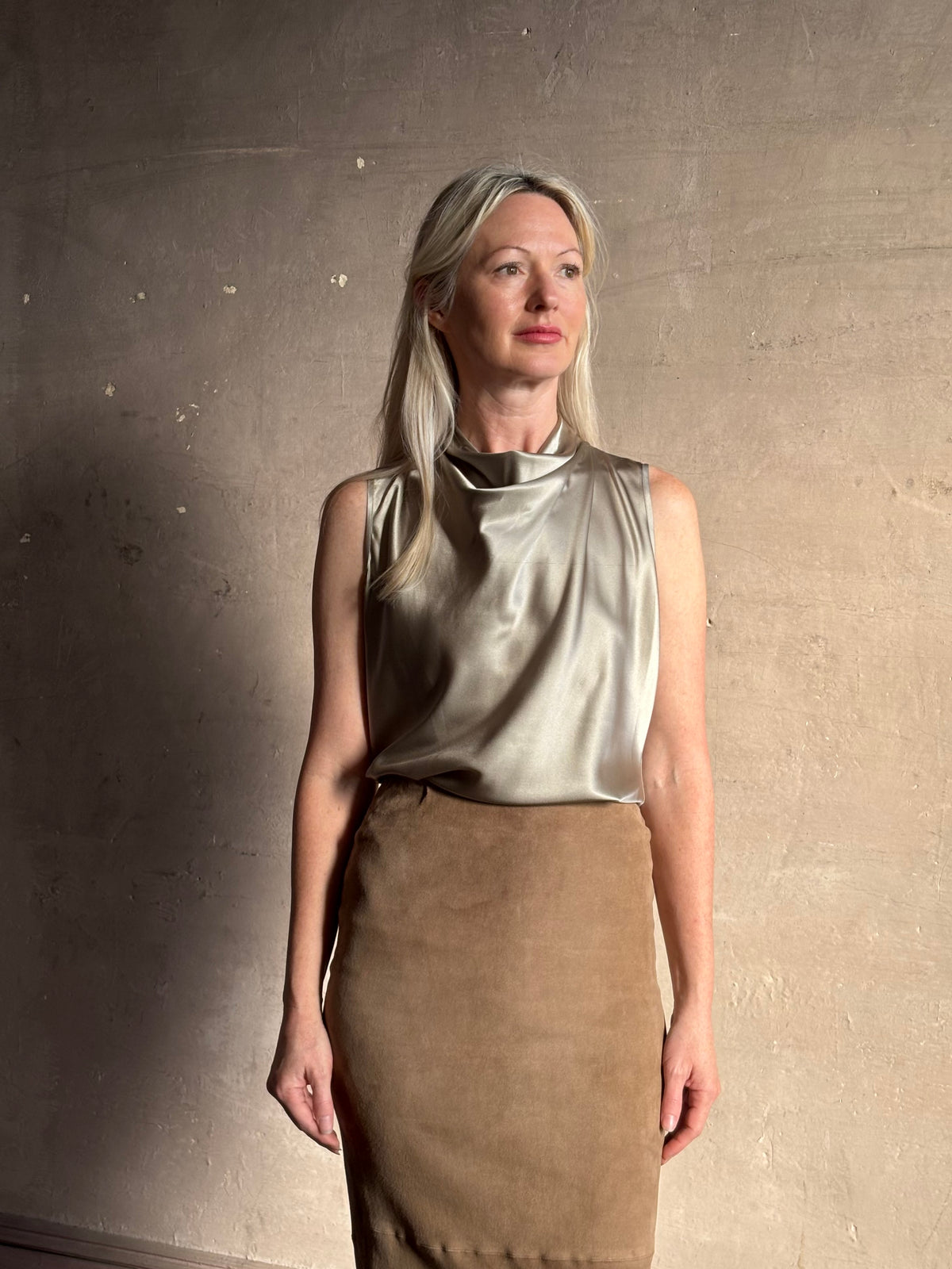 Mature woman wearing Veronica Beard Tam Top in Pewter silk blend waterfall neckline and sleeveless with fluid draping perfect for luxury layering options