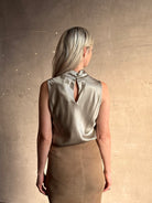 Mature woman wearing Veronica Beard Tam Silk Top in Pewter silk blend fabric-covered keyhole button back closure sleeveless