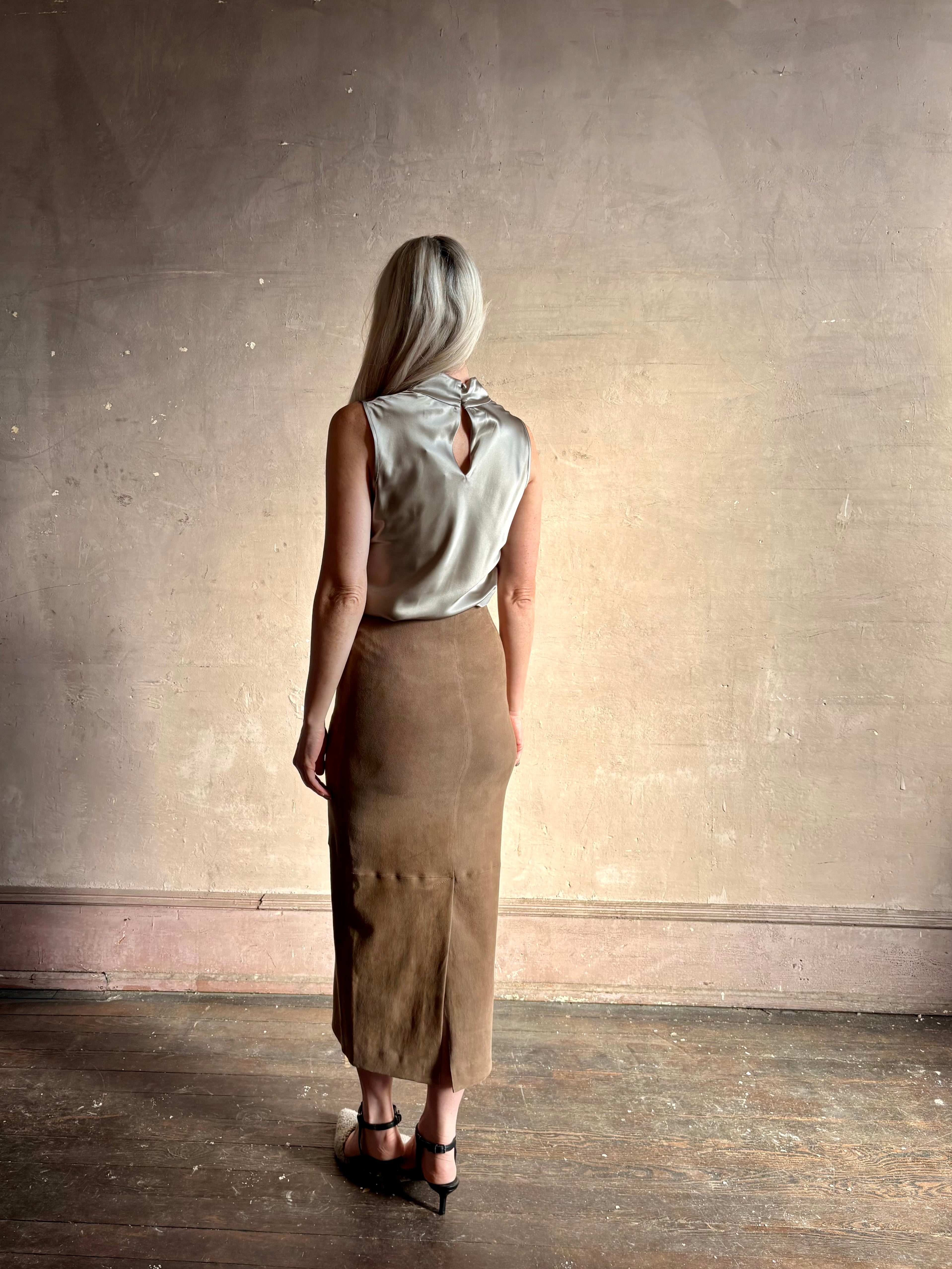 Mature woman wearing Veronica Beard Tam Silk Pewter Top tucked in and styled with a suede leather pencil skirt showing back fluid sihlouette