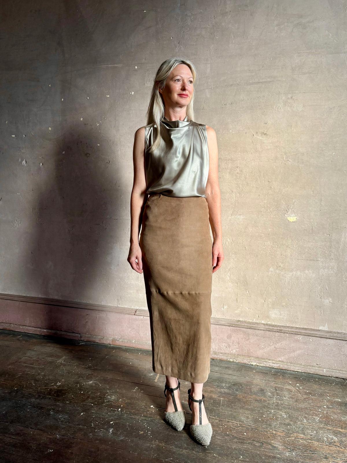 Mature woman wearing Veronica Beard Tam Silk Top in Pewter with a suede leather pencil skirt quietly luminous and occassion ready